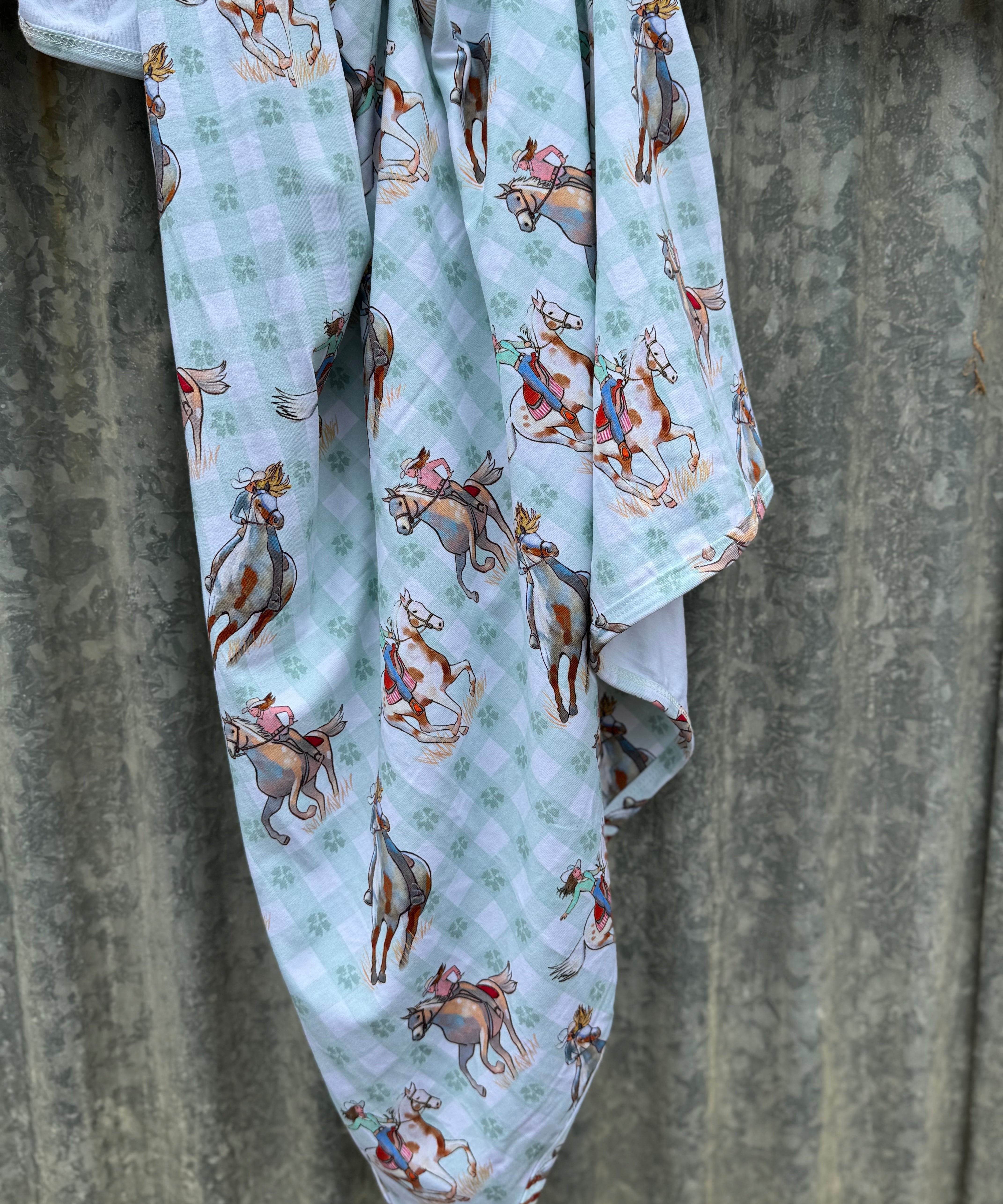 Teal cowgirl jersey organic cotton swaddle showing soft teal cowgirl print on 100% organic cotton