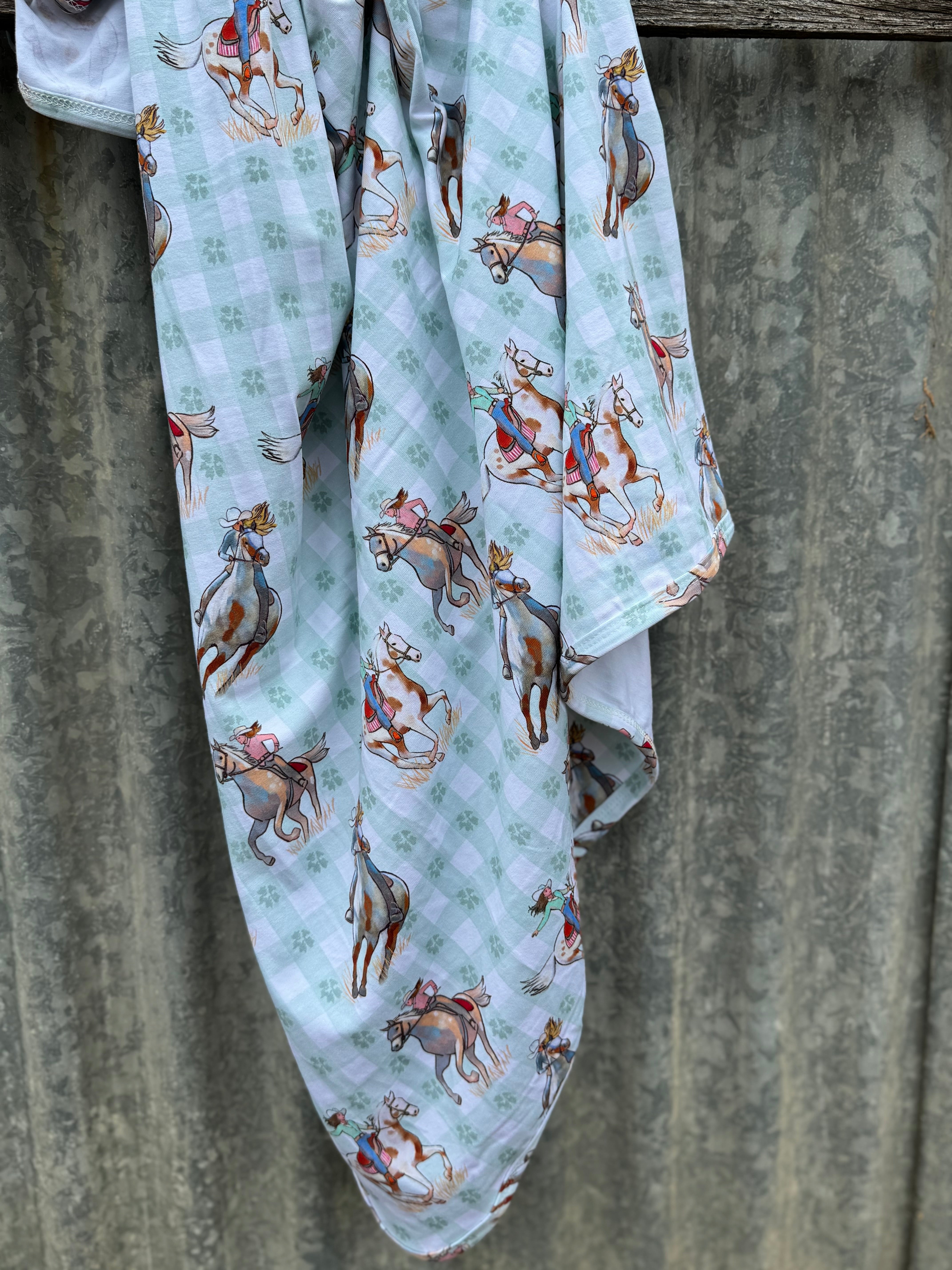 Teal cowgirl jersey organic cotton swaddle showing soft teal cowgirl print on 100% organic cotton