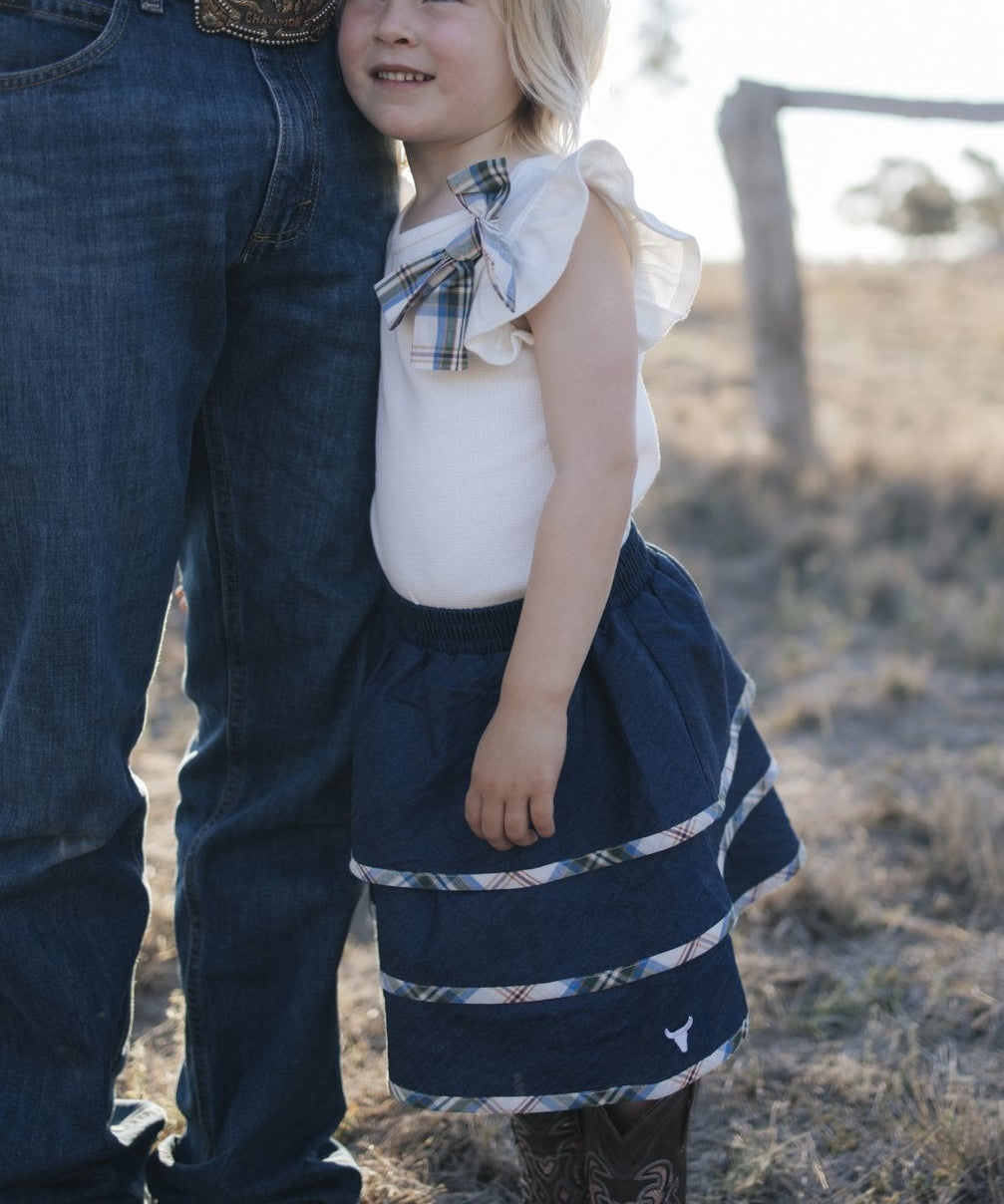 Girl in denim tiered skirt and white top