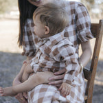 Baby boy gingham bodysuit on mum's lap