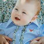 Dasha soft baby blue gingham short sleeve romper back view showing snap closure and soft blue gingham