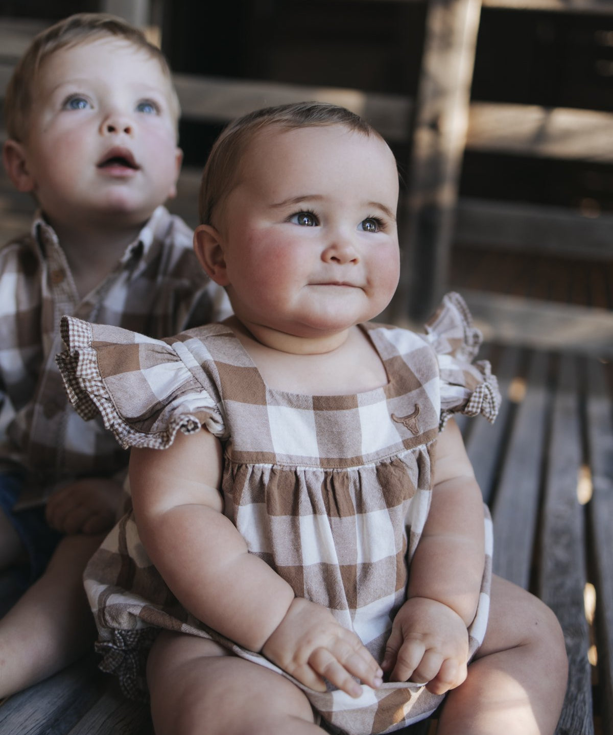 Baby girl in gingham romper with gingham frill sleeves