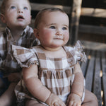 Baby girl in gingham romper with gingham frill sleeves