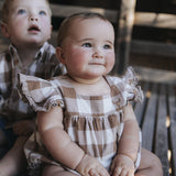 Baby girl in gingham romper with gingham frill sleeves