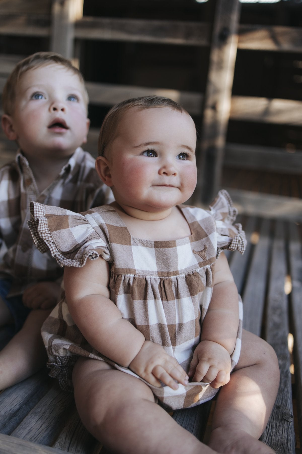 Baby girl in gingham romper with gingham frill sleeves