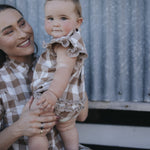 Baby gingham romper held by mum