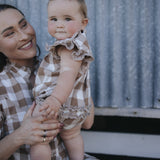 Baby gingham romper held by mum