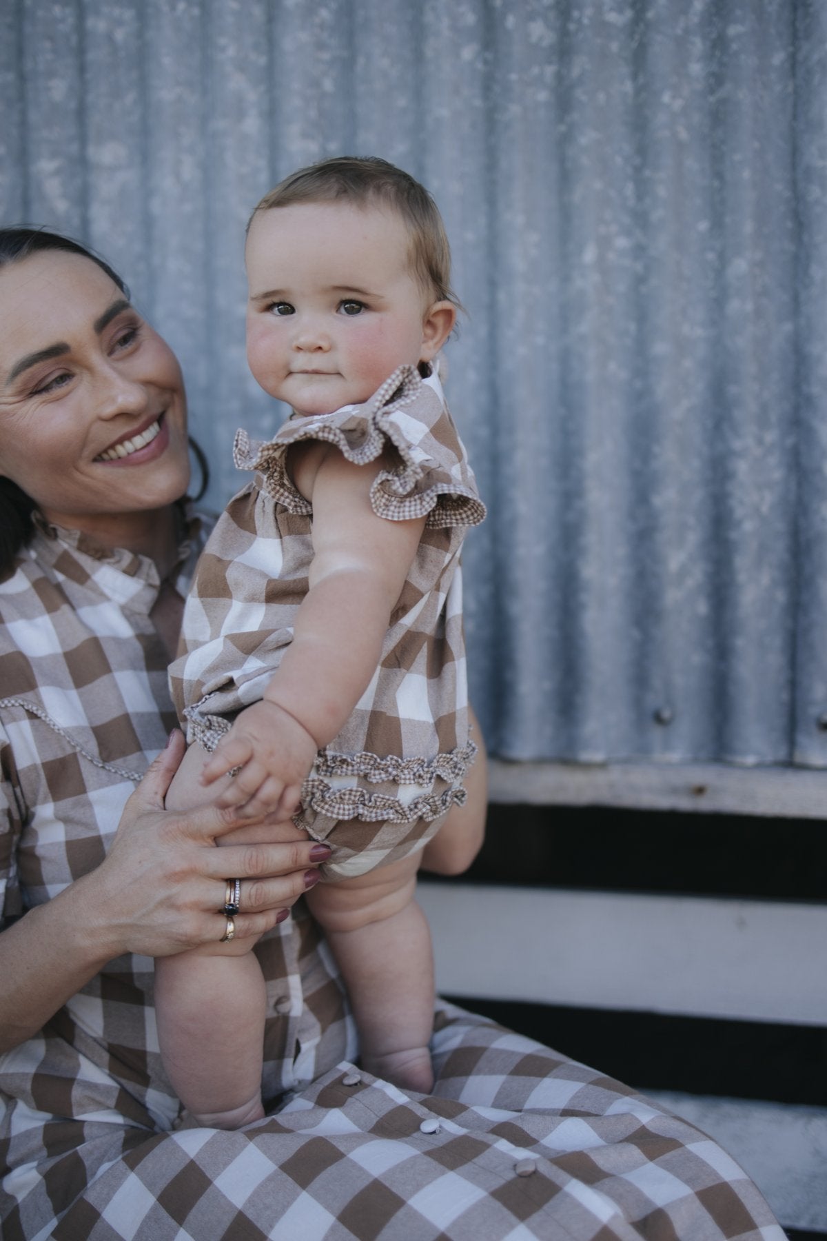 Baby gingham romper held by mum