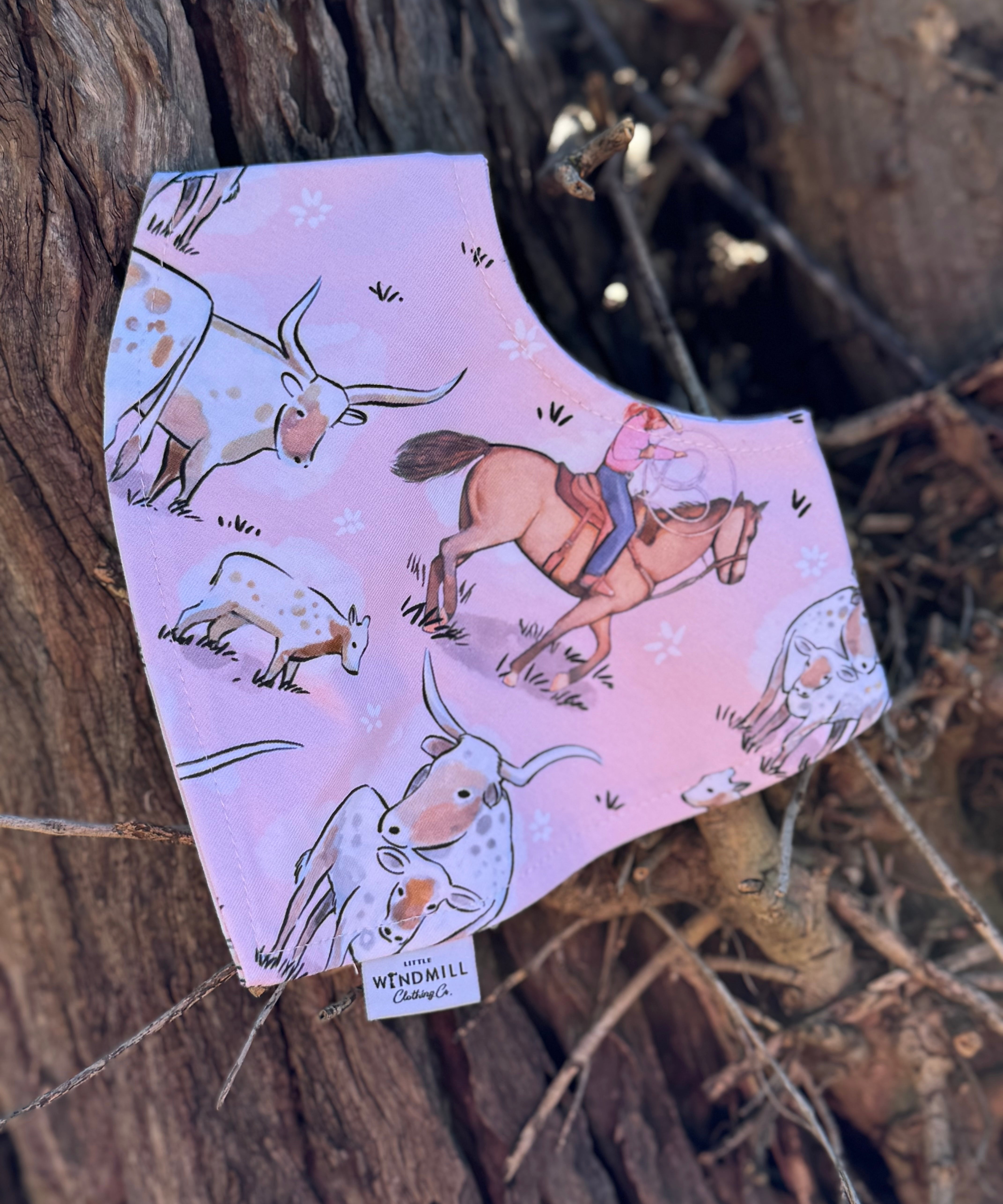 Waterproof pink long horn bib front view showing adorable pink longhorn cattle print on wipeable waterproof fabric