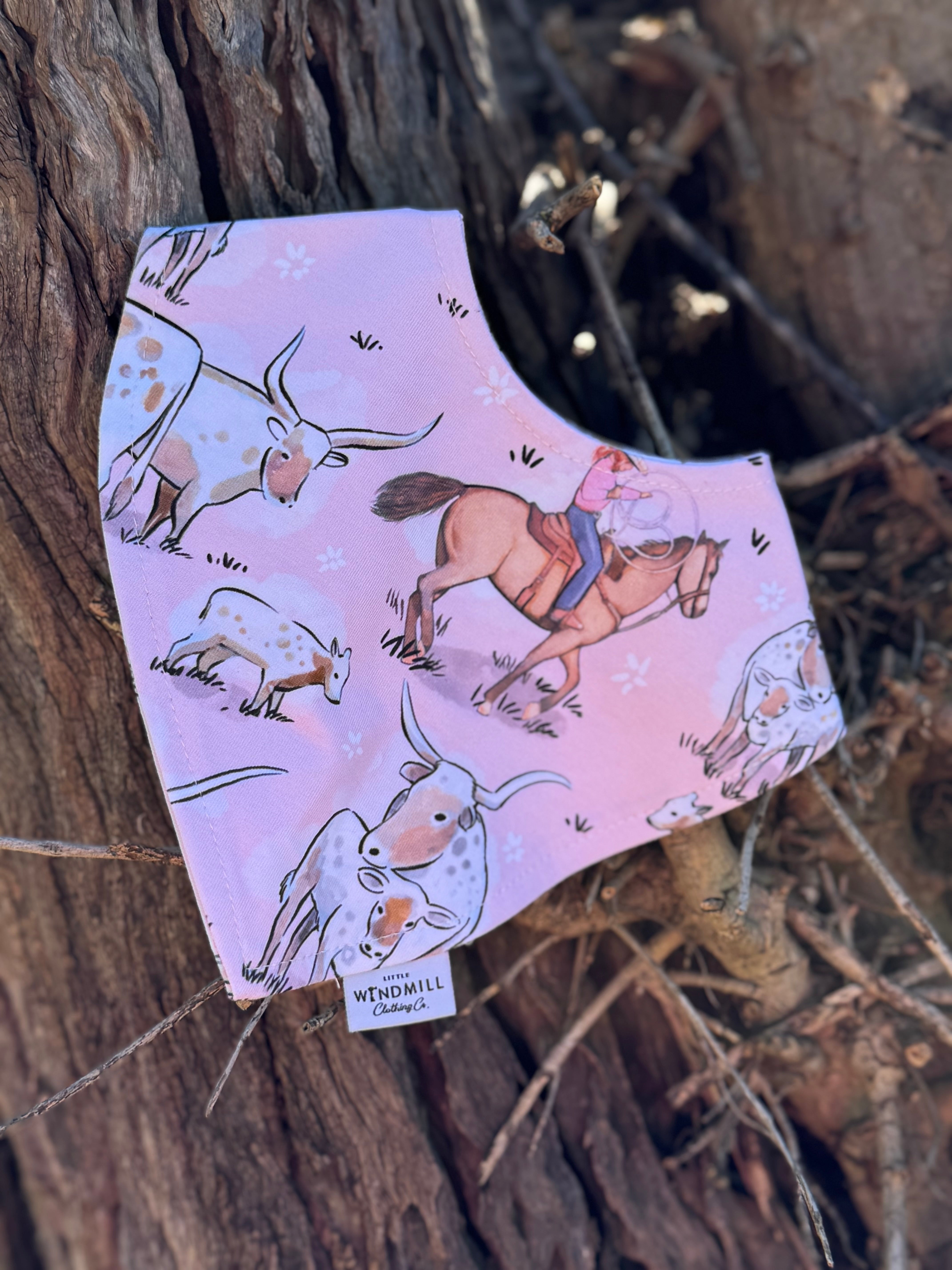 Waterproof pink long horn bib front view showing adorable pink longhorn cattle print on wipeable waterproof fabric