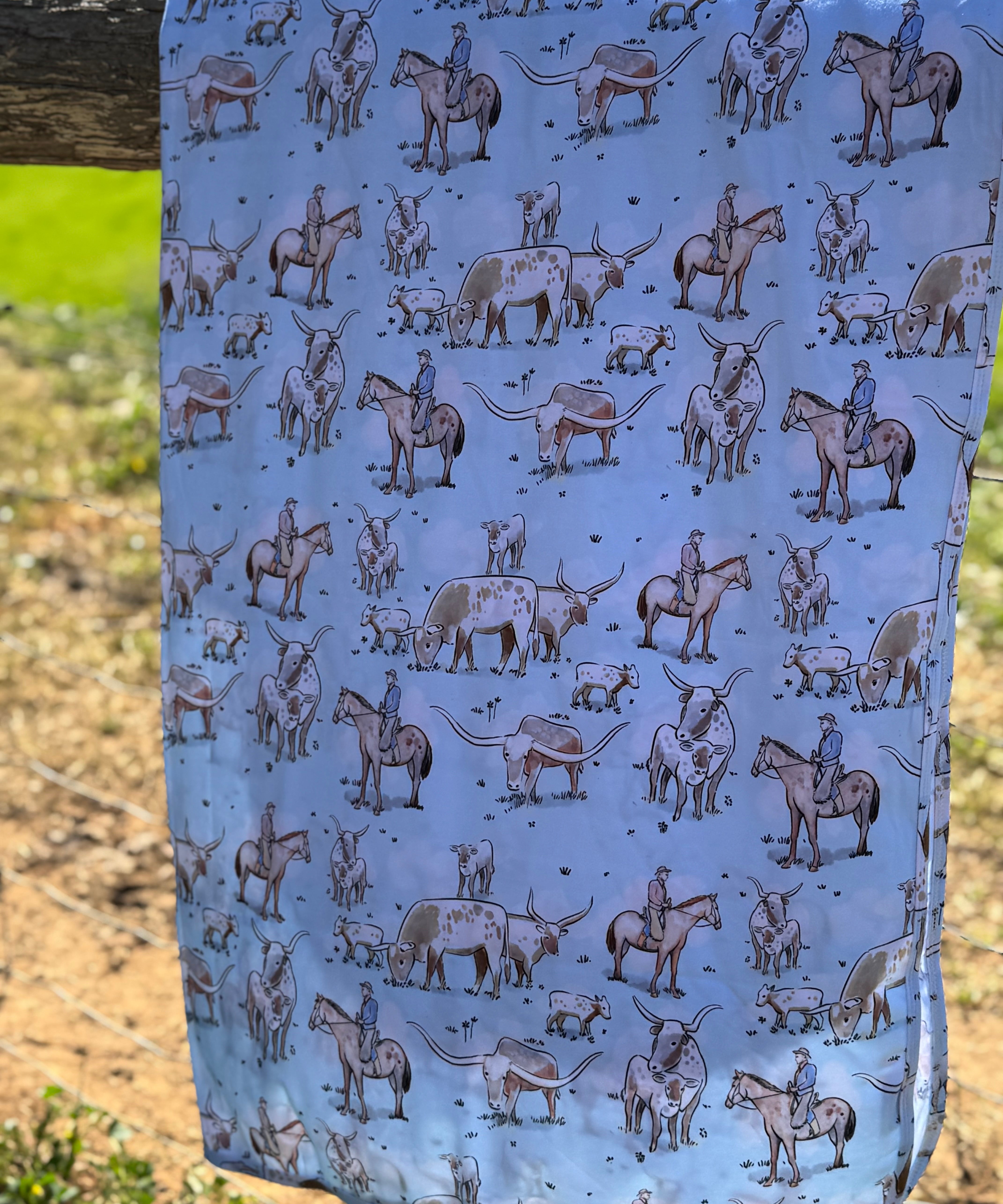 Blue long horn organic cotton swaddle draped showing generous swaddle size for newborns