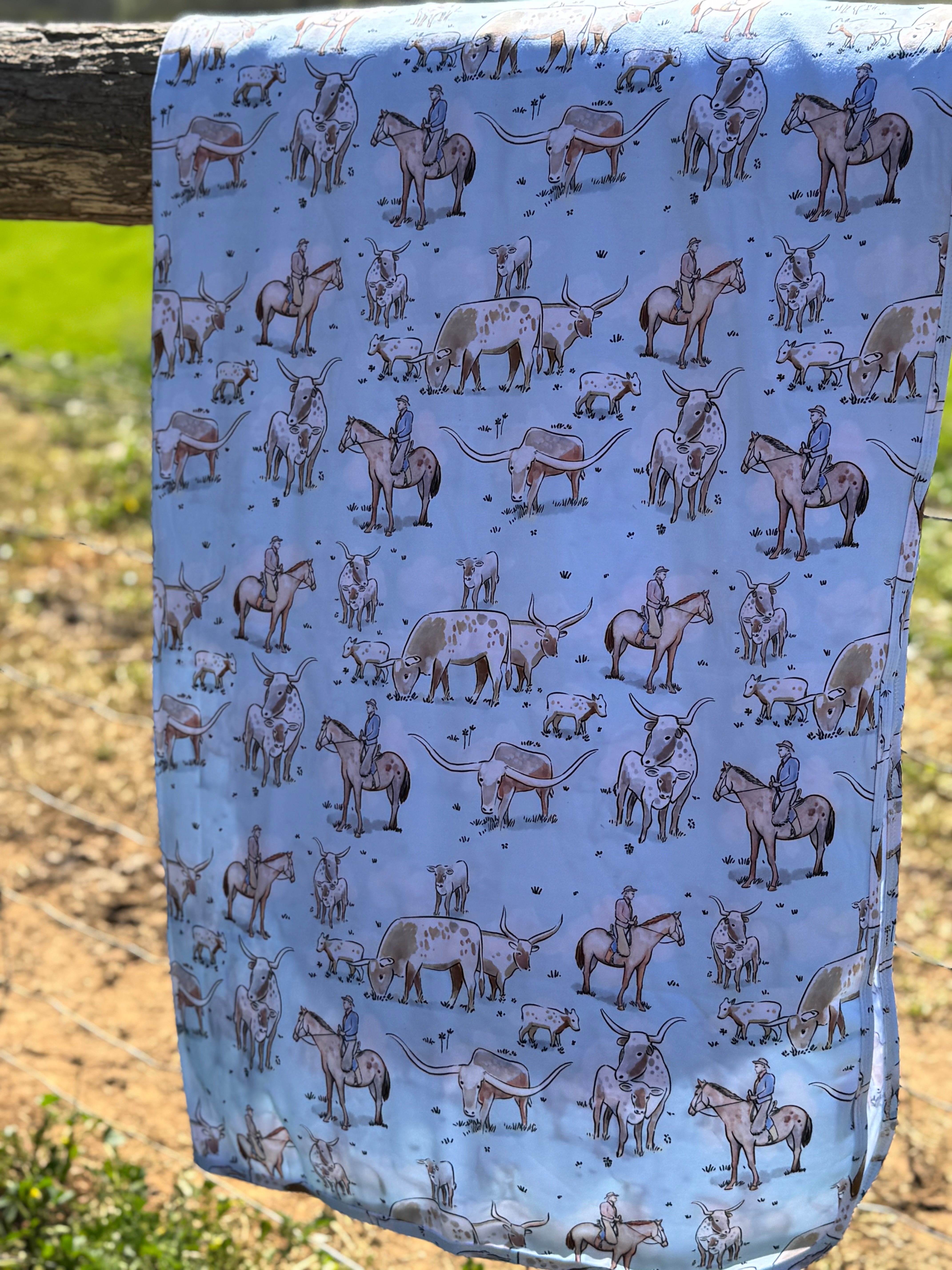 Blue long horn organic cotton swaddle draped showing generous swaddle size for newborns