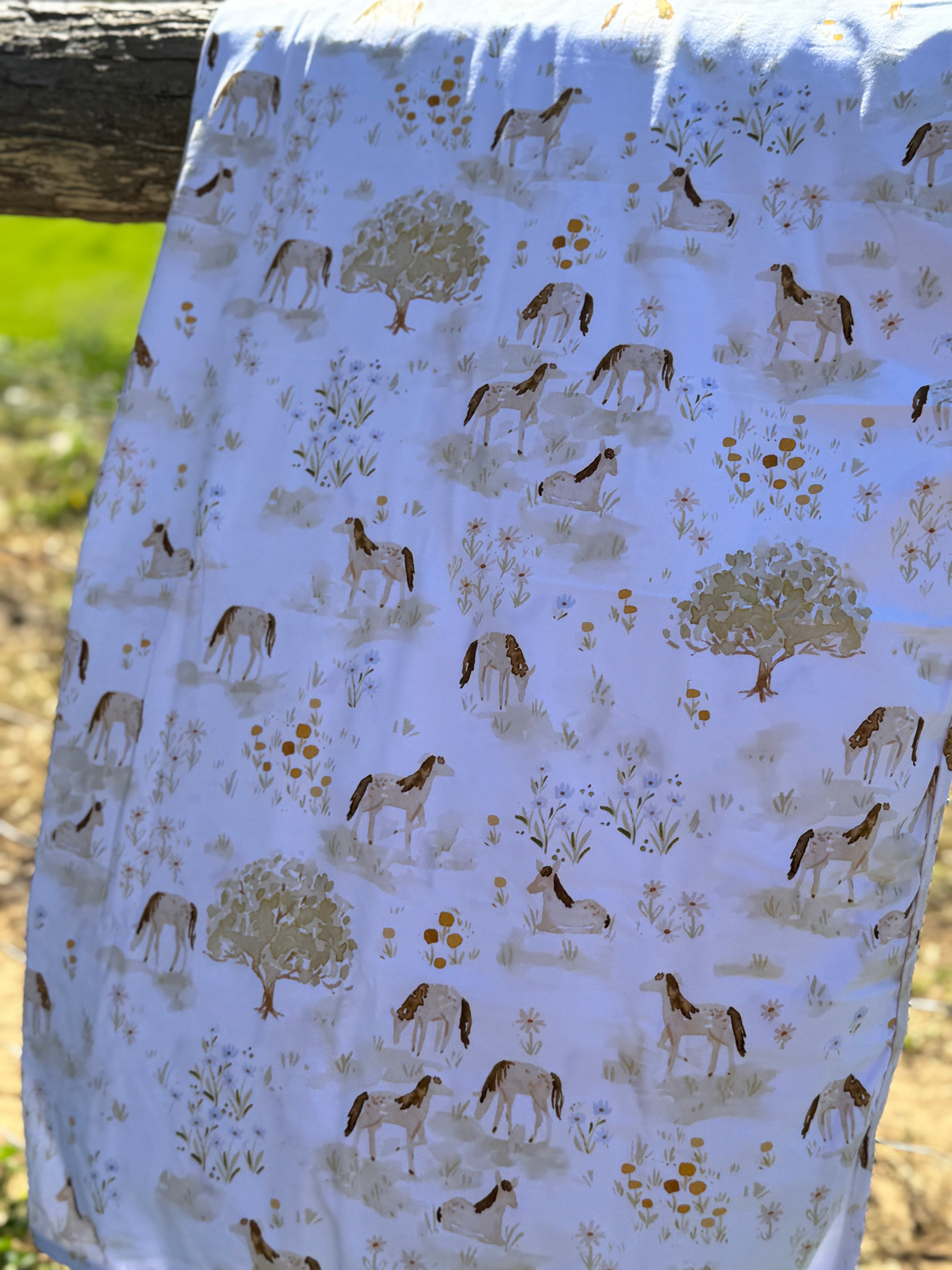 Horse field organic cotton swaddle draped showing generous size for swaddling and wrapping