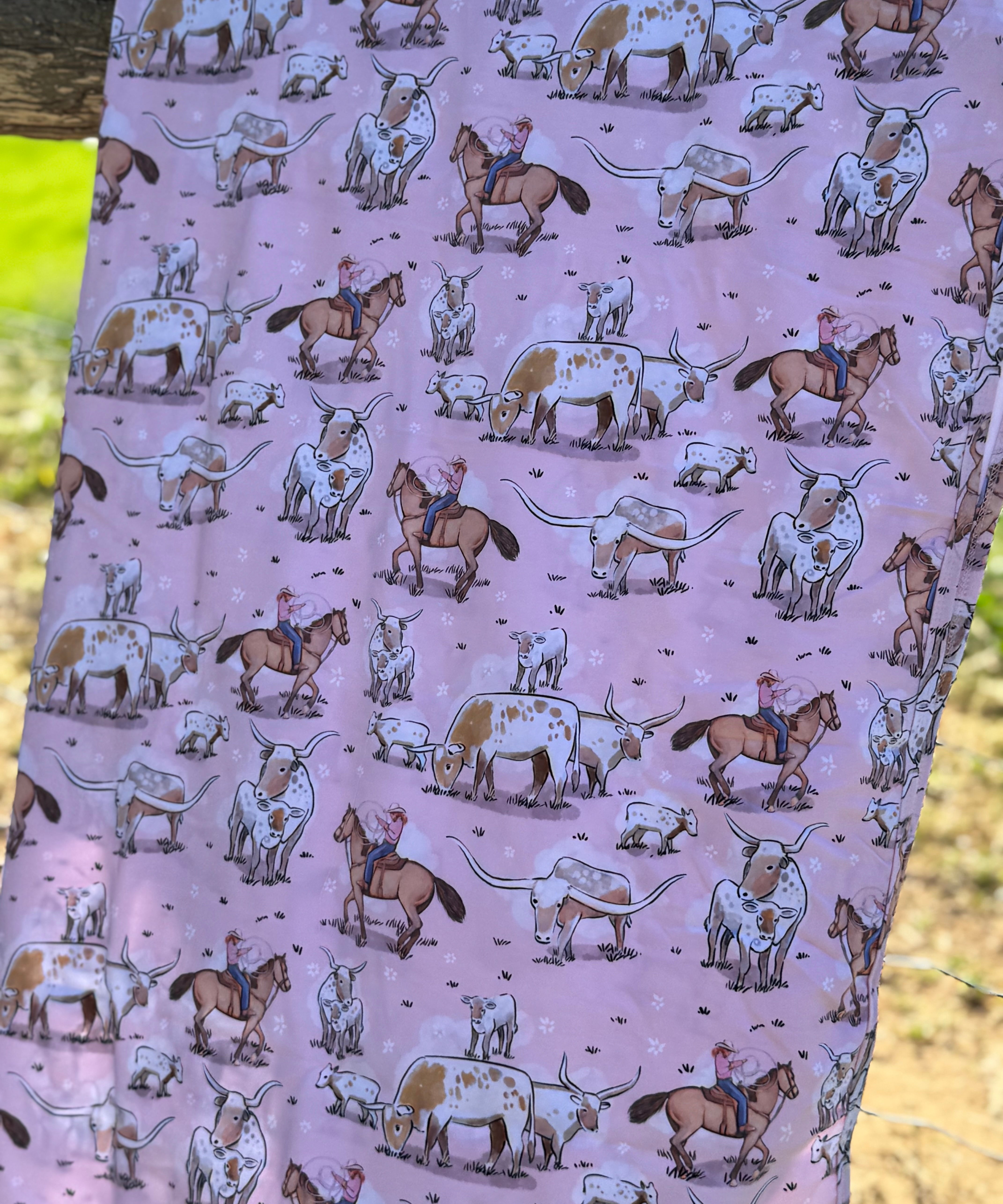 Pink long horn swaddle print close-up showing detailed longhorn motifs on organic jersey cotton