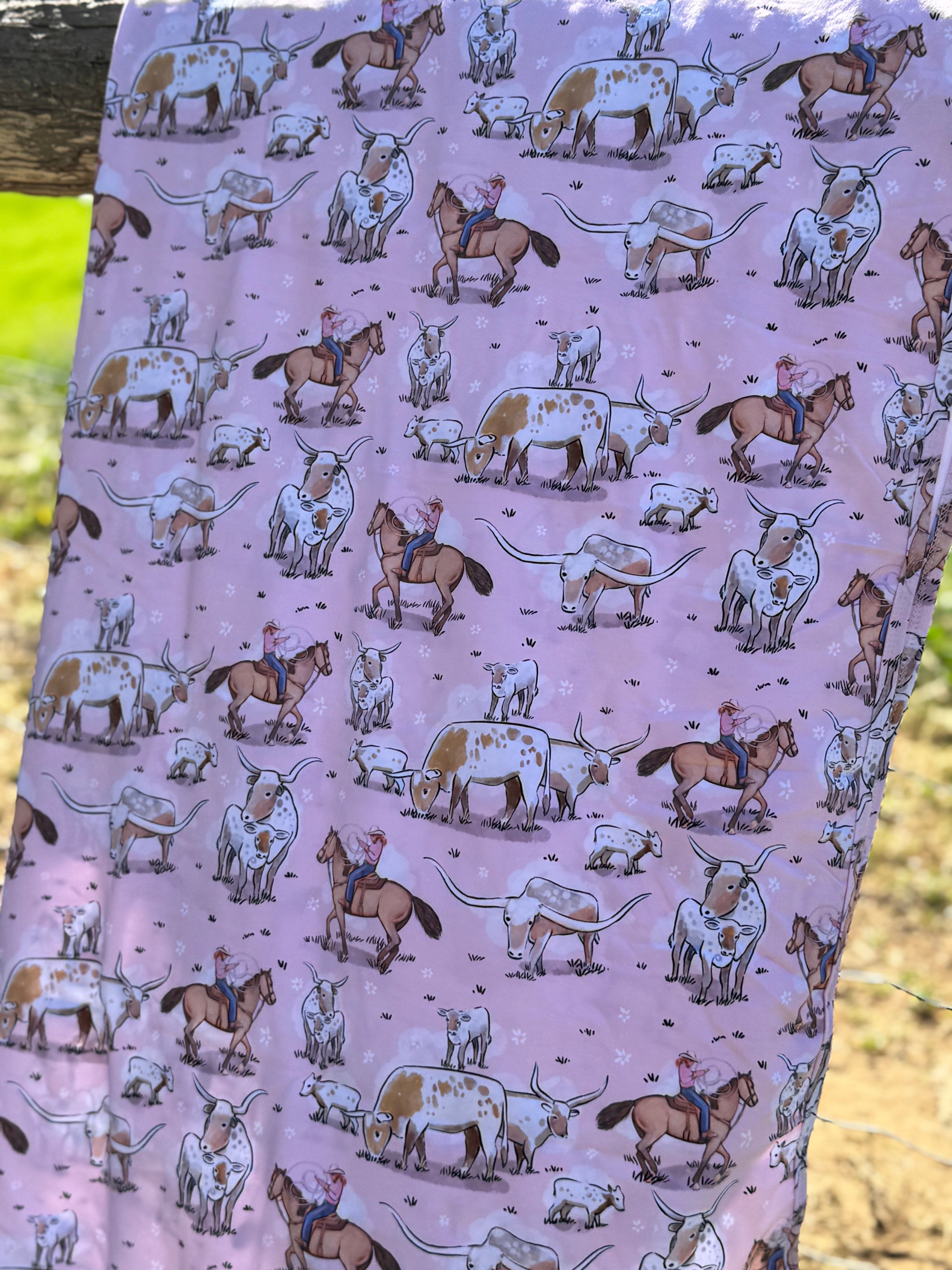 Pink long horn swaddle print close-up showing detailed longhorn motifs on organic jersey cotton
