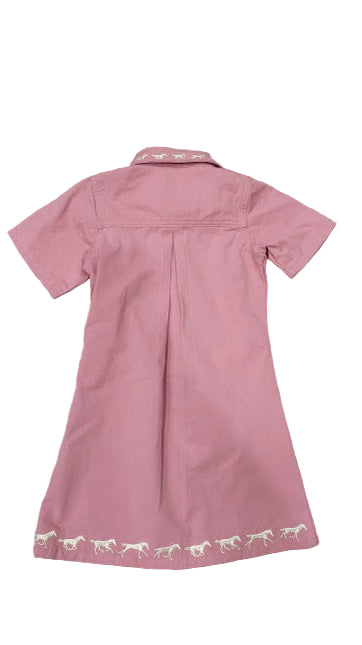 Pink dress with white lace trim on a wooden floor