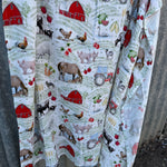 Farm yard organic muslin swaddle open flat lay showing full size and farm yard print pattern