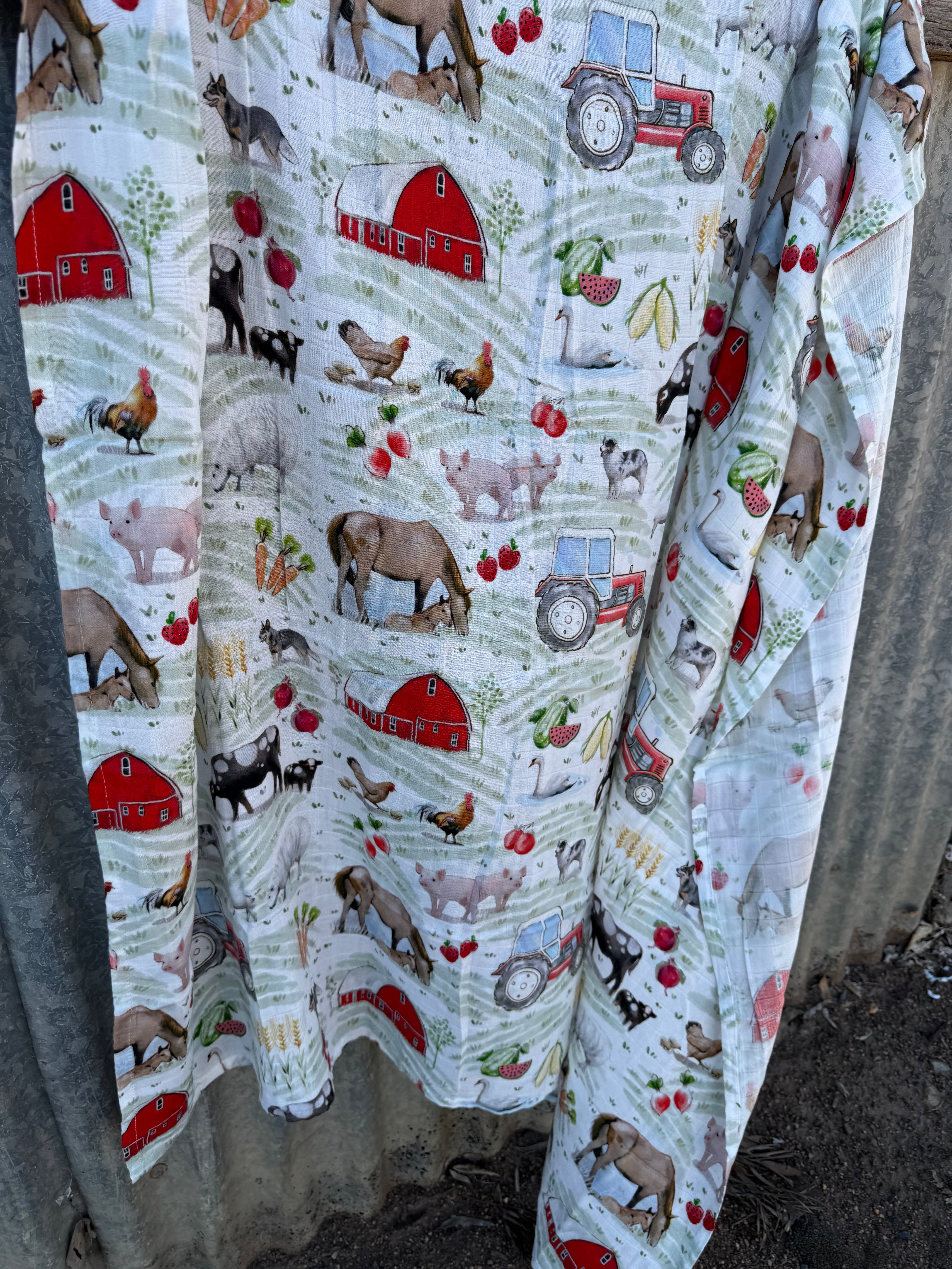 Farm yard organic muslin swaddle open flat lay showing full size and farm yard print pattern
