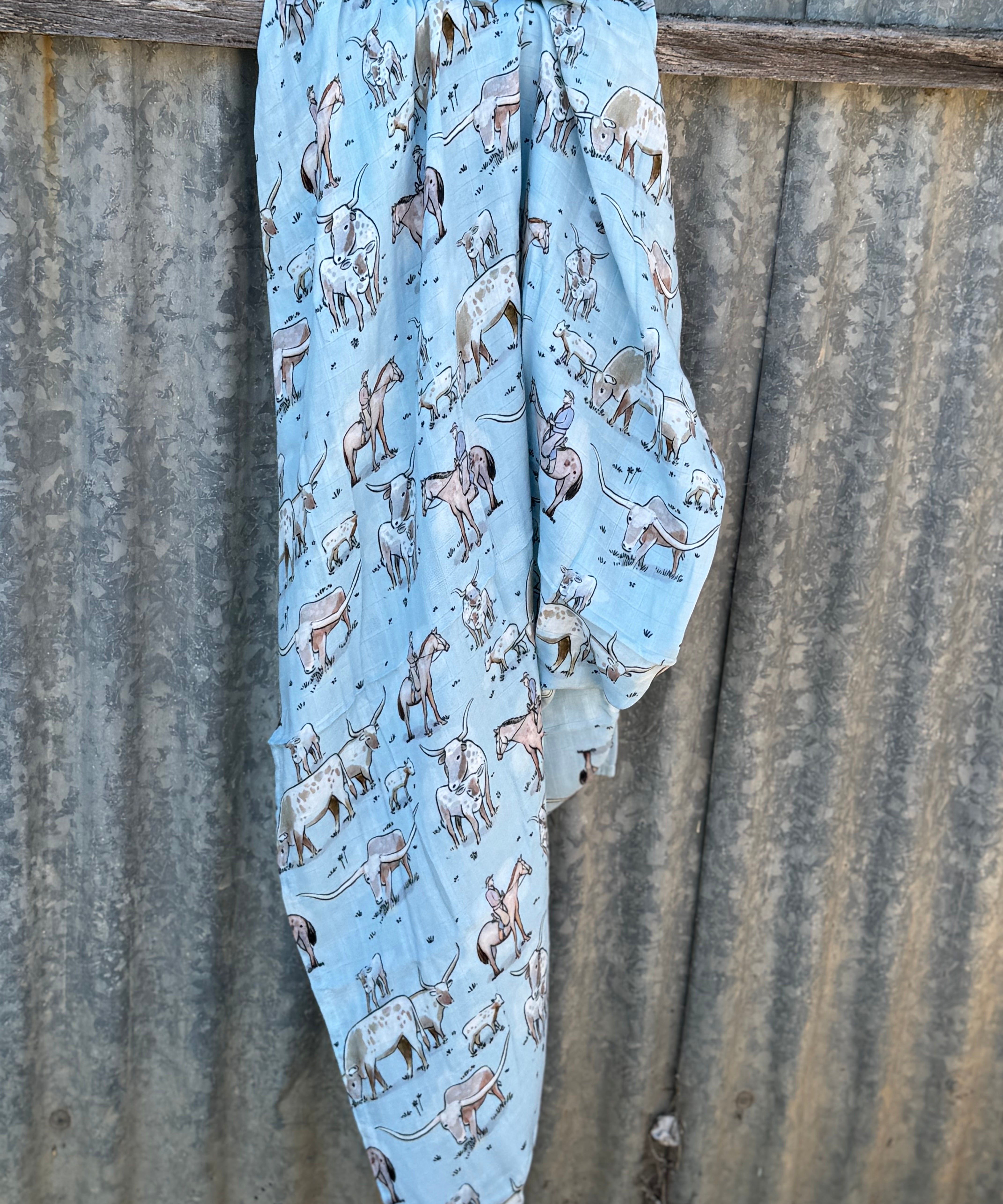 Organic light cotton muslin blue longhorn swaddle showing delicate blue longhorn print on breathable organic muslin