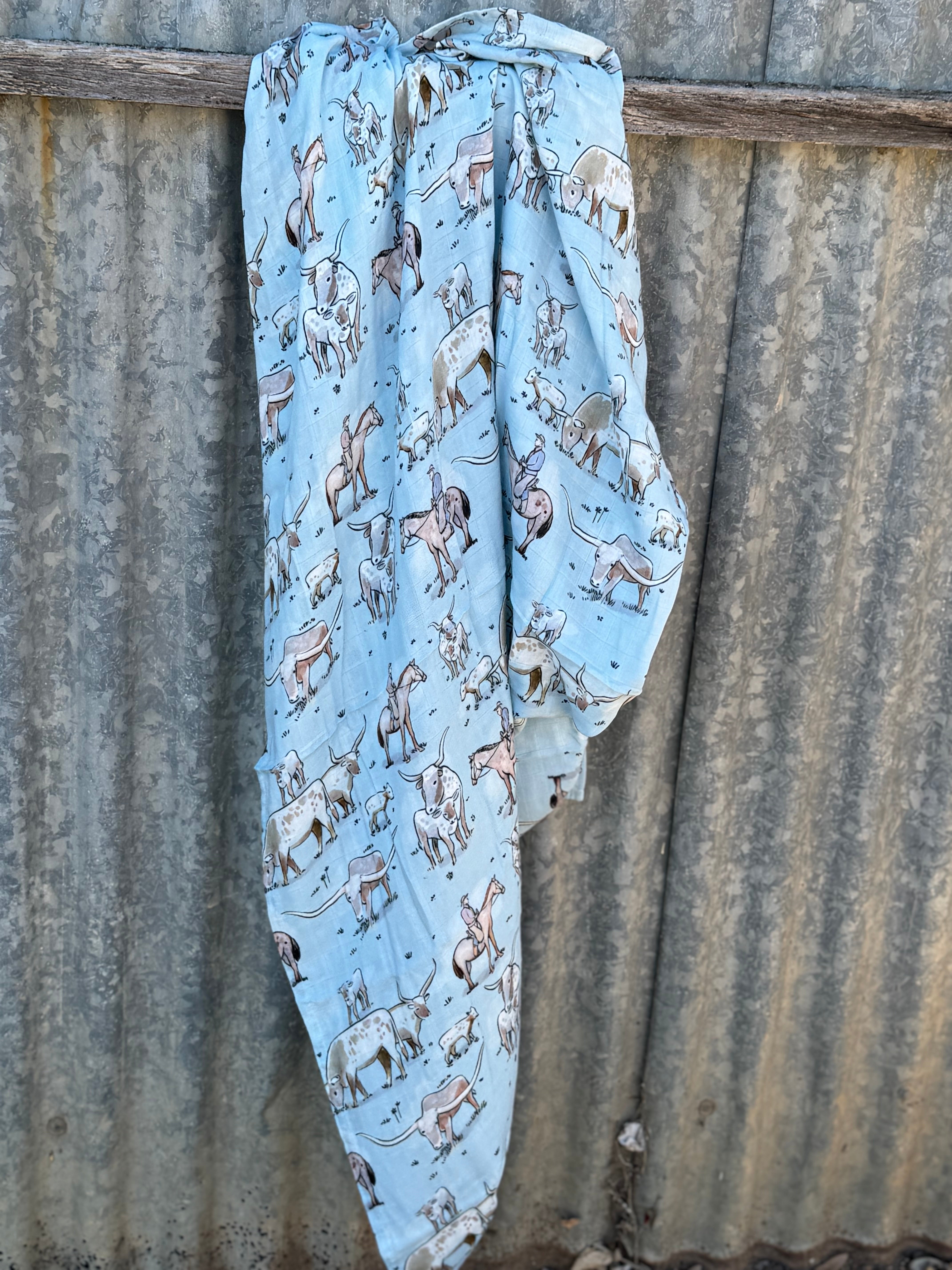 Organic light cotton muslin blue longhorn swaddle showing delicate blue longhorn print on breathable organic muslin
