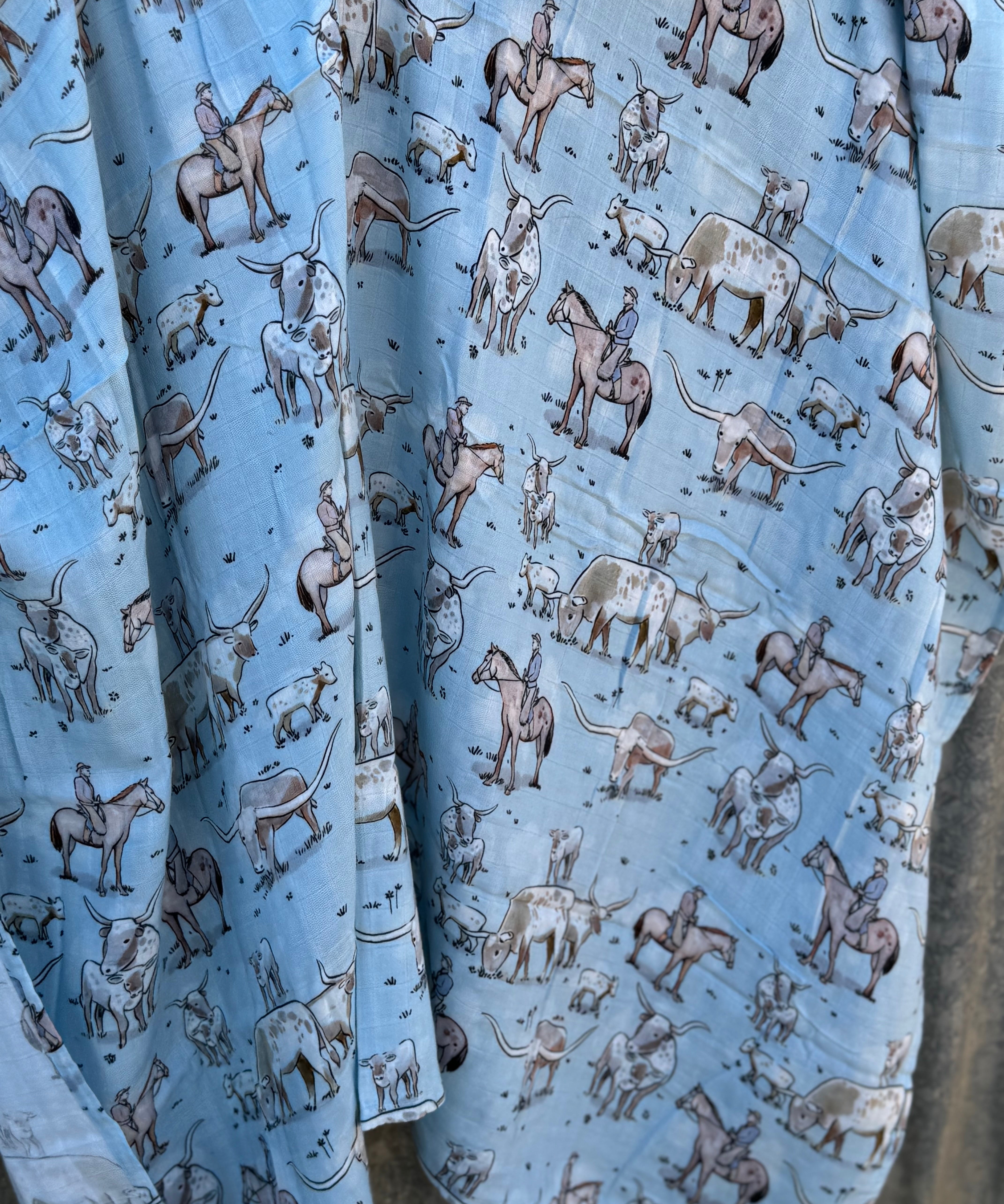Blue longhorn muslin swaddle print close-up showing longhorn motifs on fine organic cotton muslin