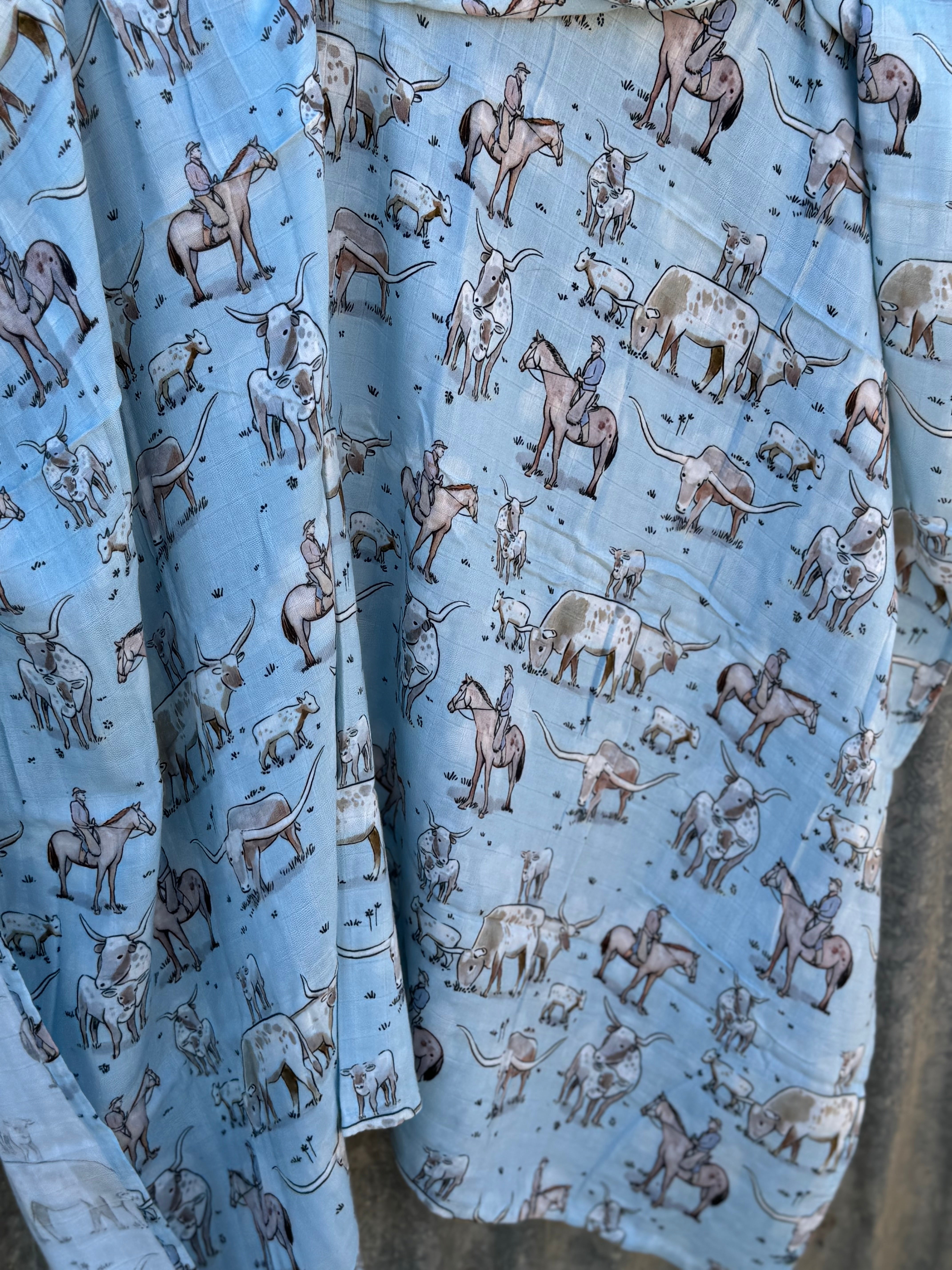 Blue longhorn muslin swaddle print close-up showing longhorn motifs on fine organic cotton muslin