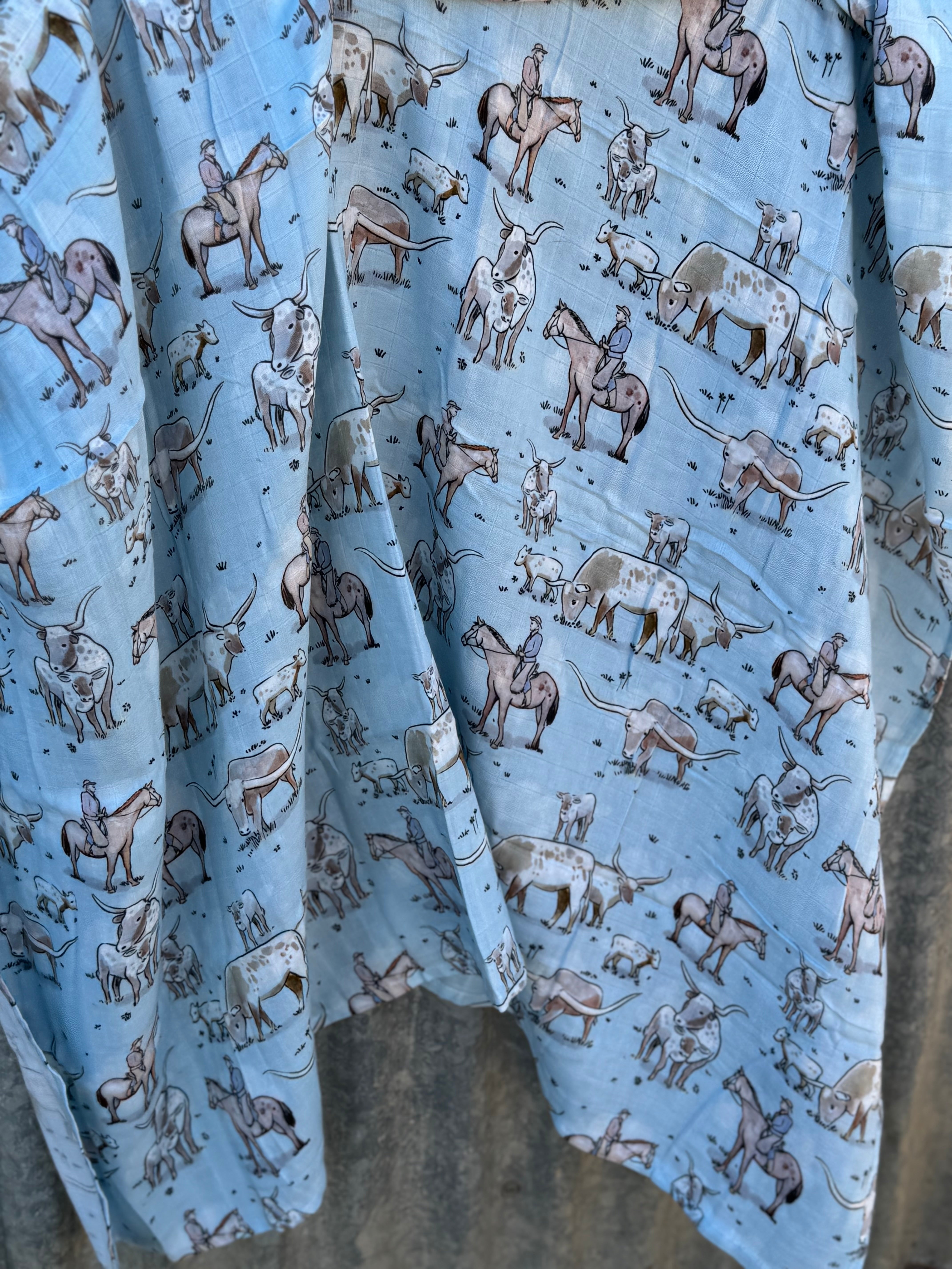 Blue longhorn organic muslin swaddle open flat lay showing full size and delicate print