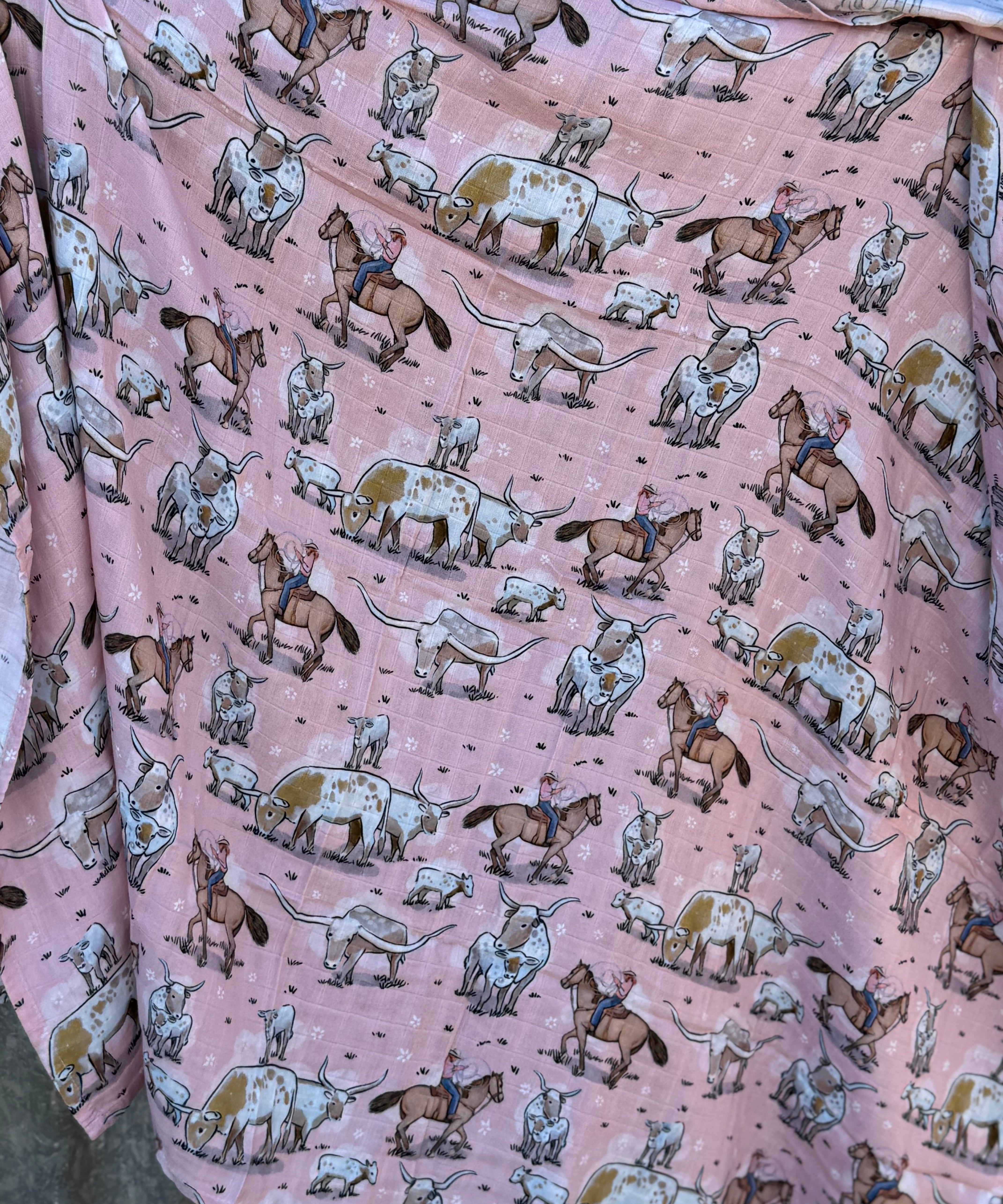Pink longhorn organic muslin swaddle open flat lay showing full size and charming pink print