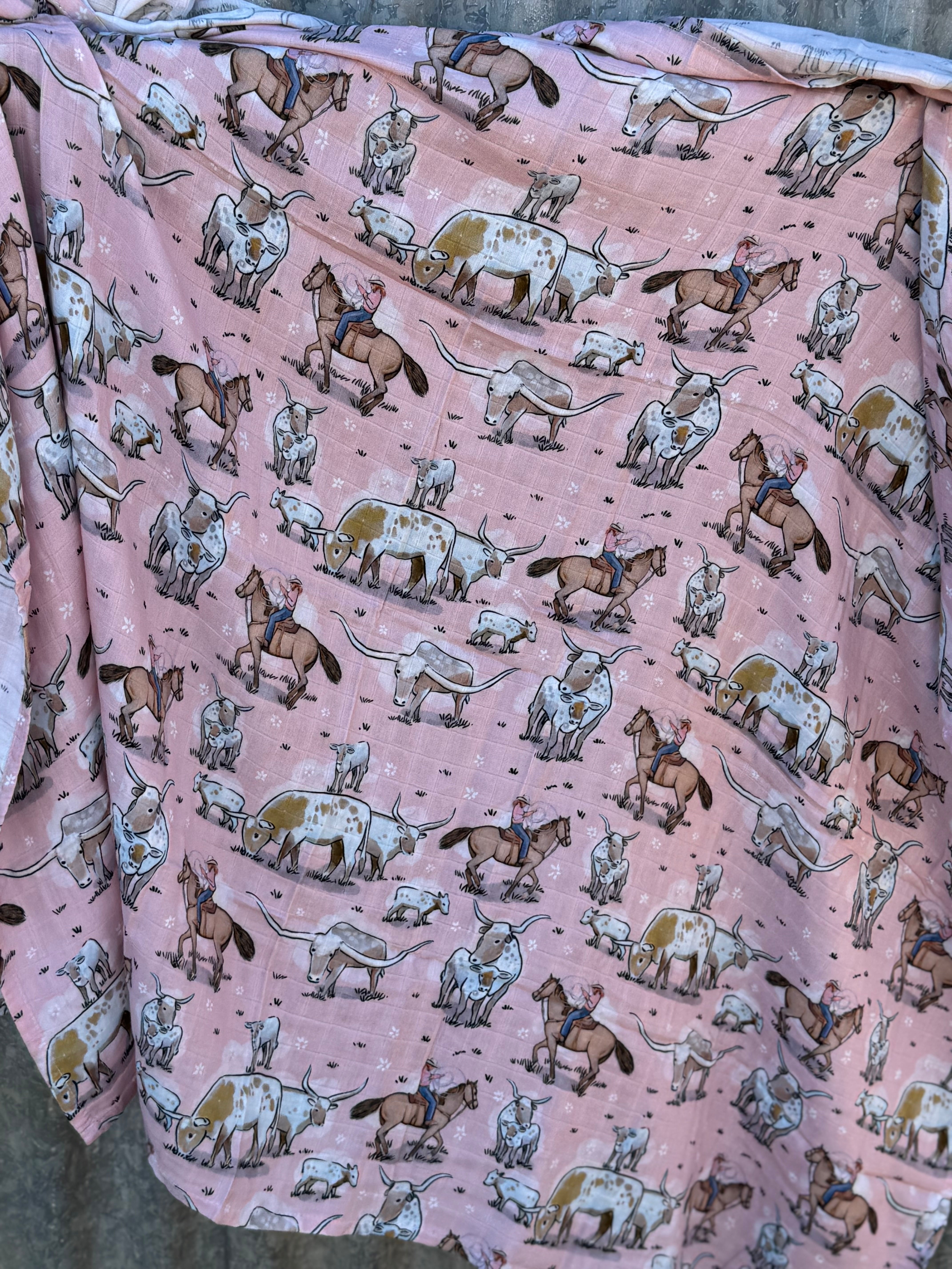 Pink longhorn organic muslin swaddle open flat lay showing full size and charming pink print