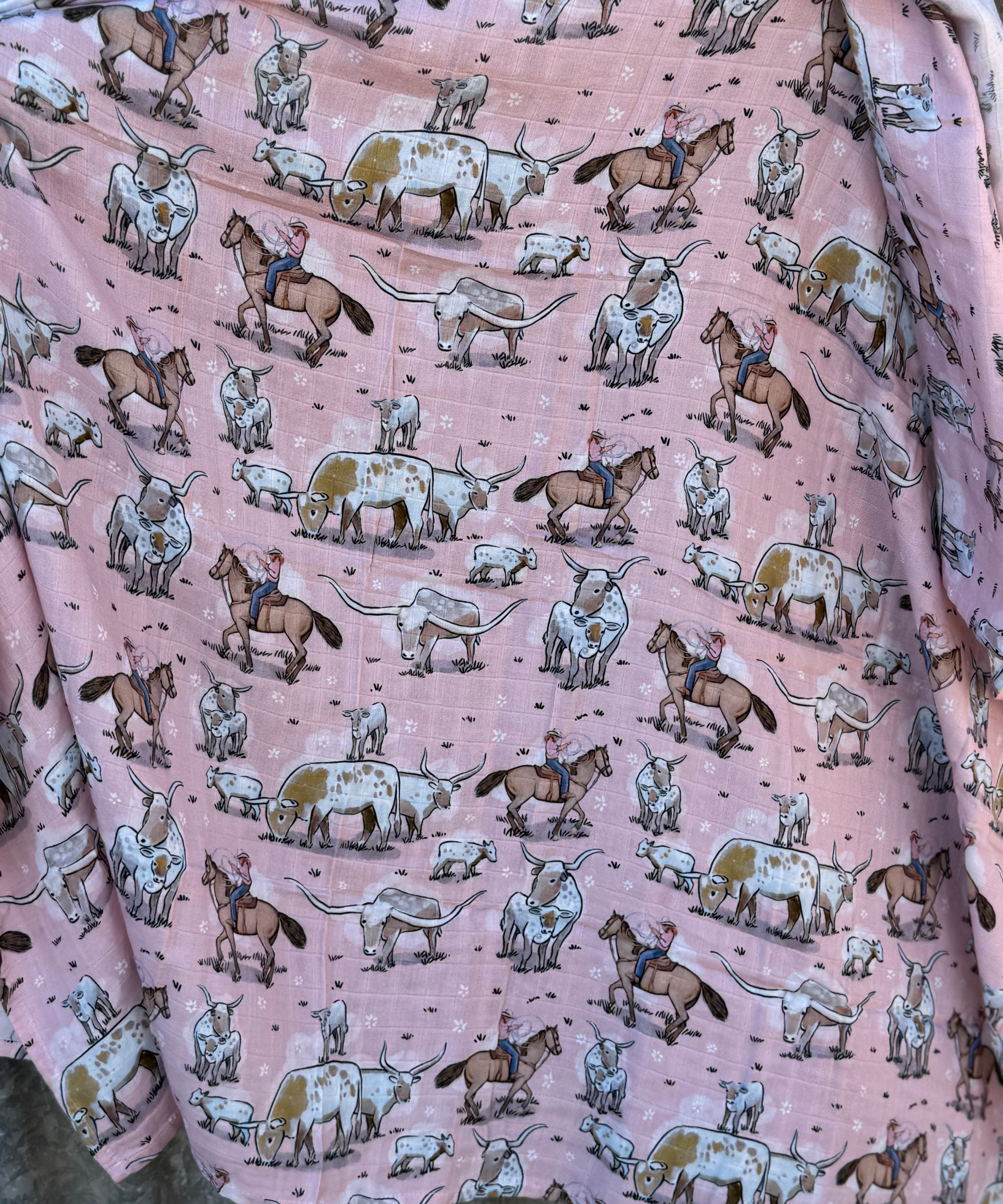Pink longhorn organic muslin swaddle draped showing lightweight breathable design for warm days