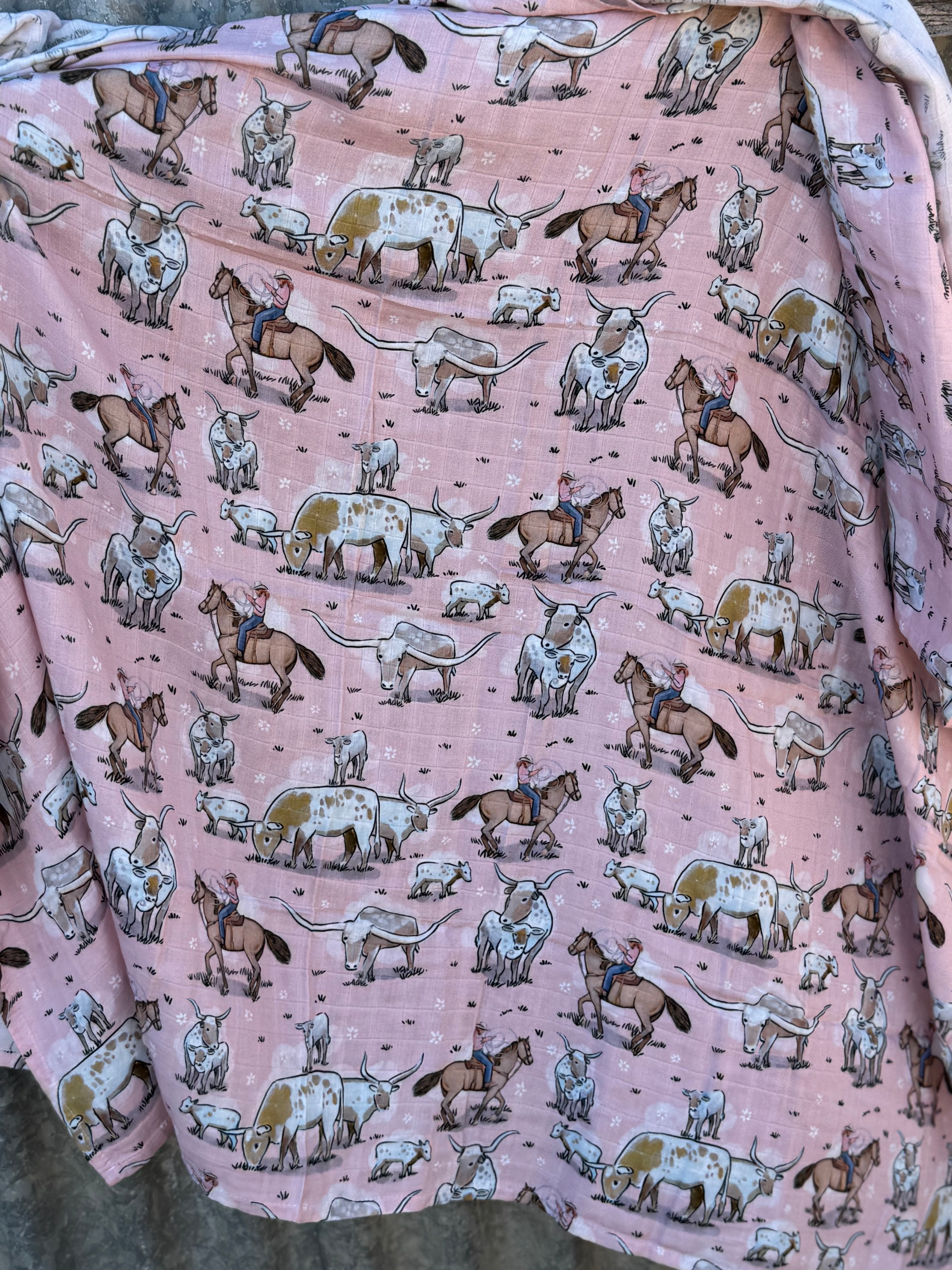Pink longhorn organic muslin swaddle draped showing lightweight breathable design for warm days
