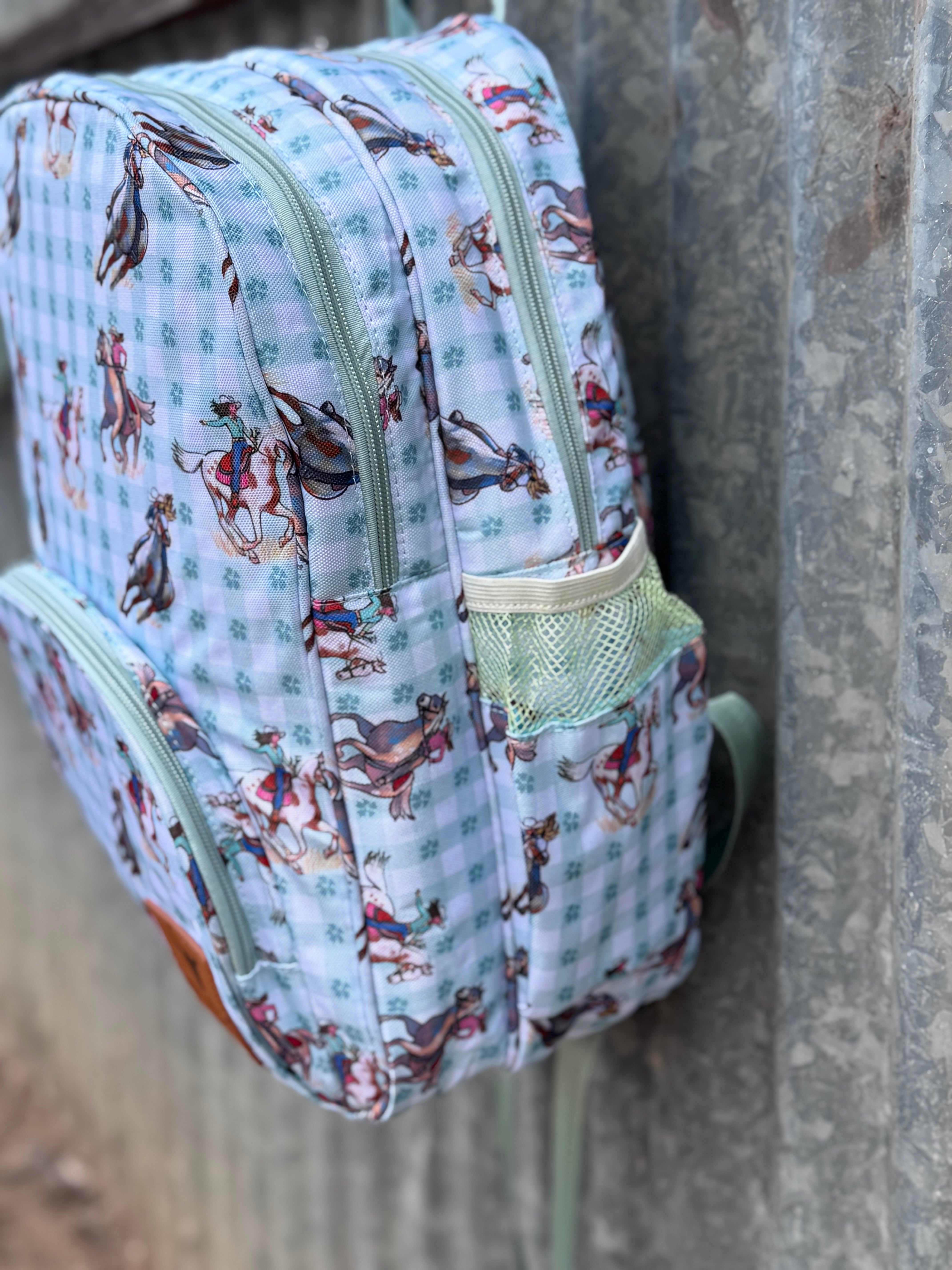 Teal cowgirl backpack open showing organised interior pockets and compartments