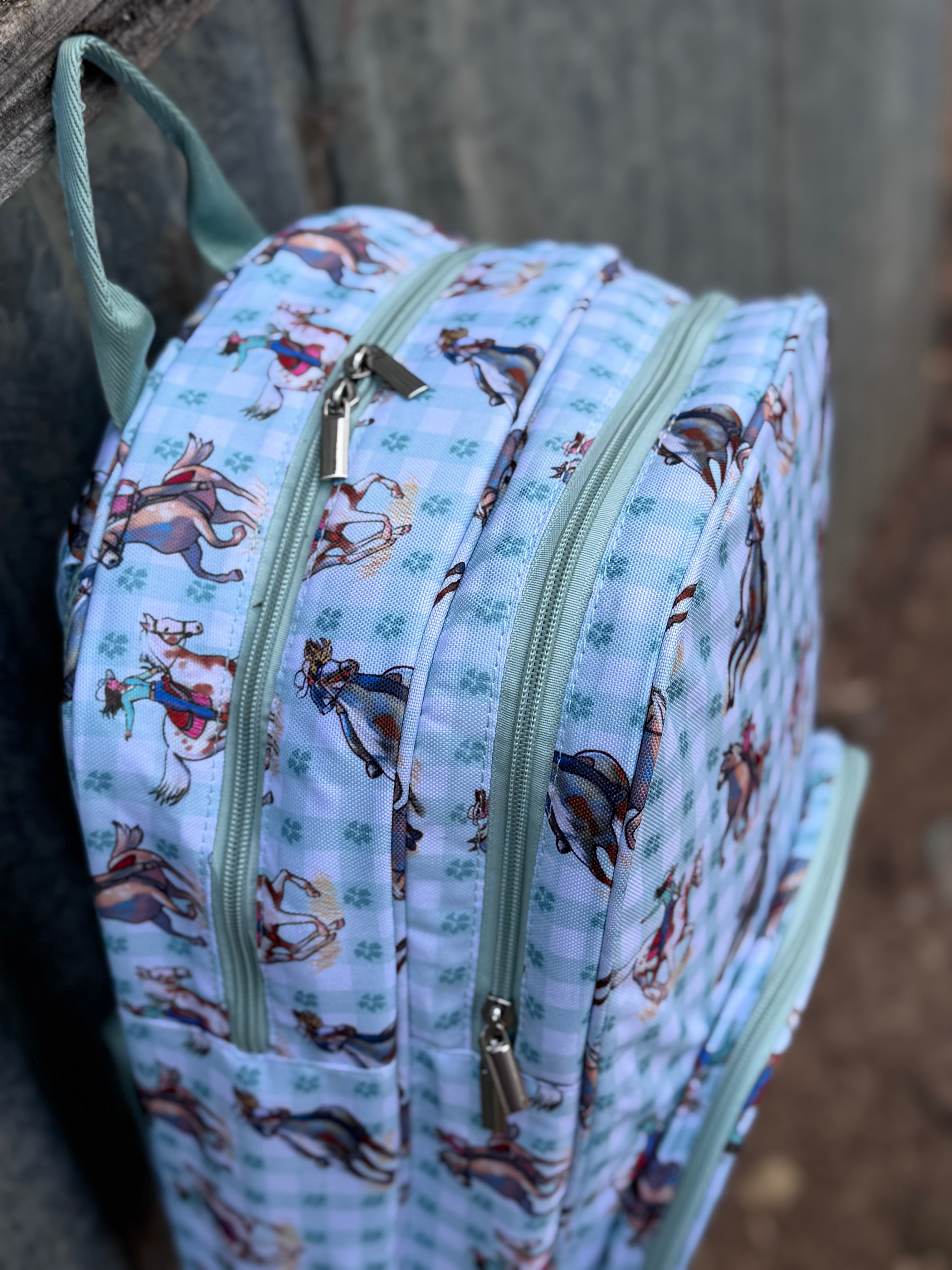 Teal cowgirl backpack flatlay showing full teal cowgirl western print school bag design