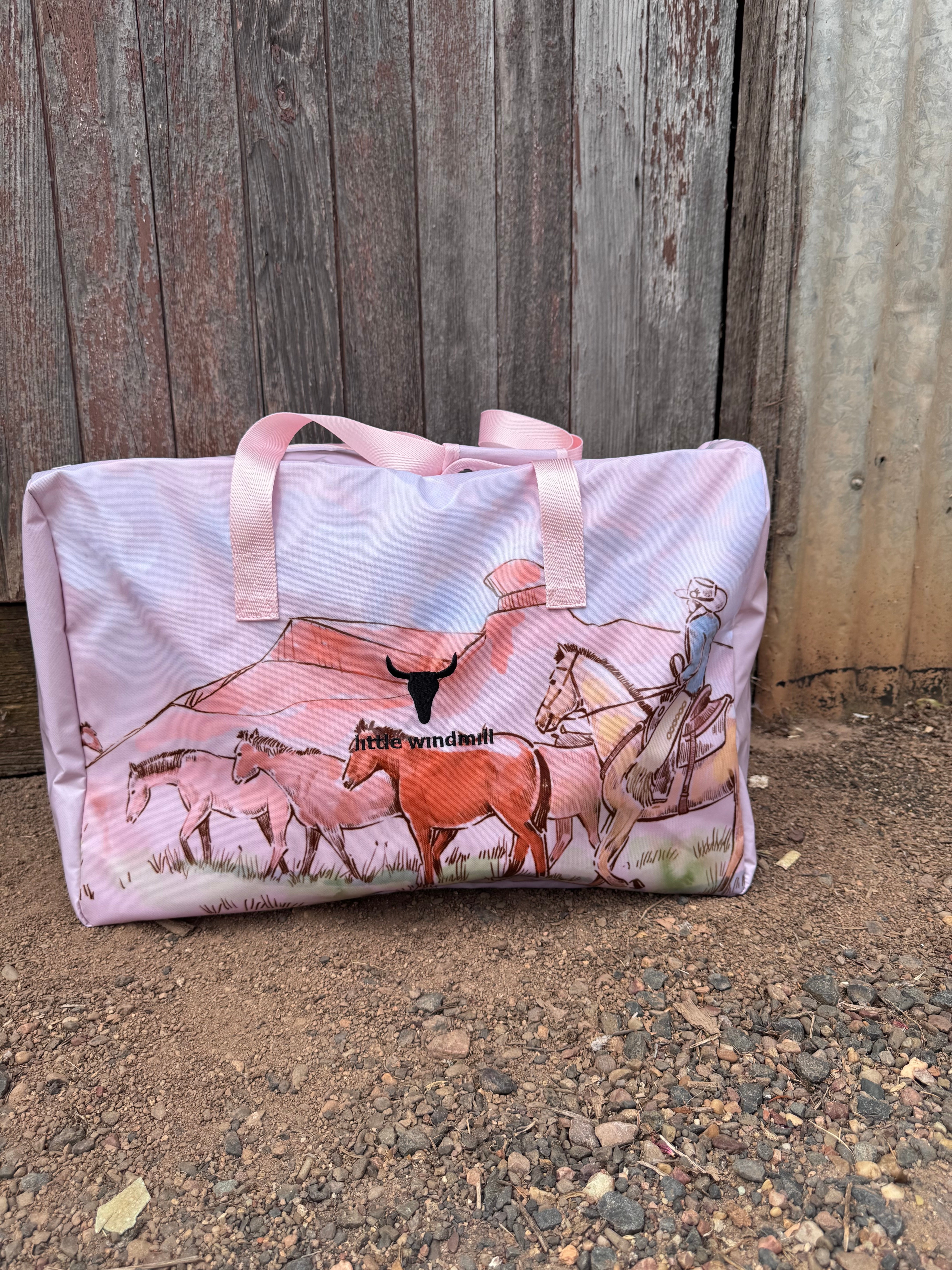 Pastel pink droving duffle bag front view showing sweet pastel pink western droving print travel bag