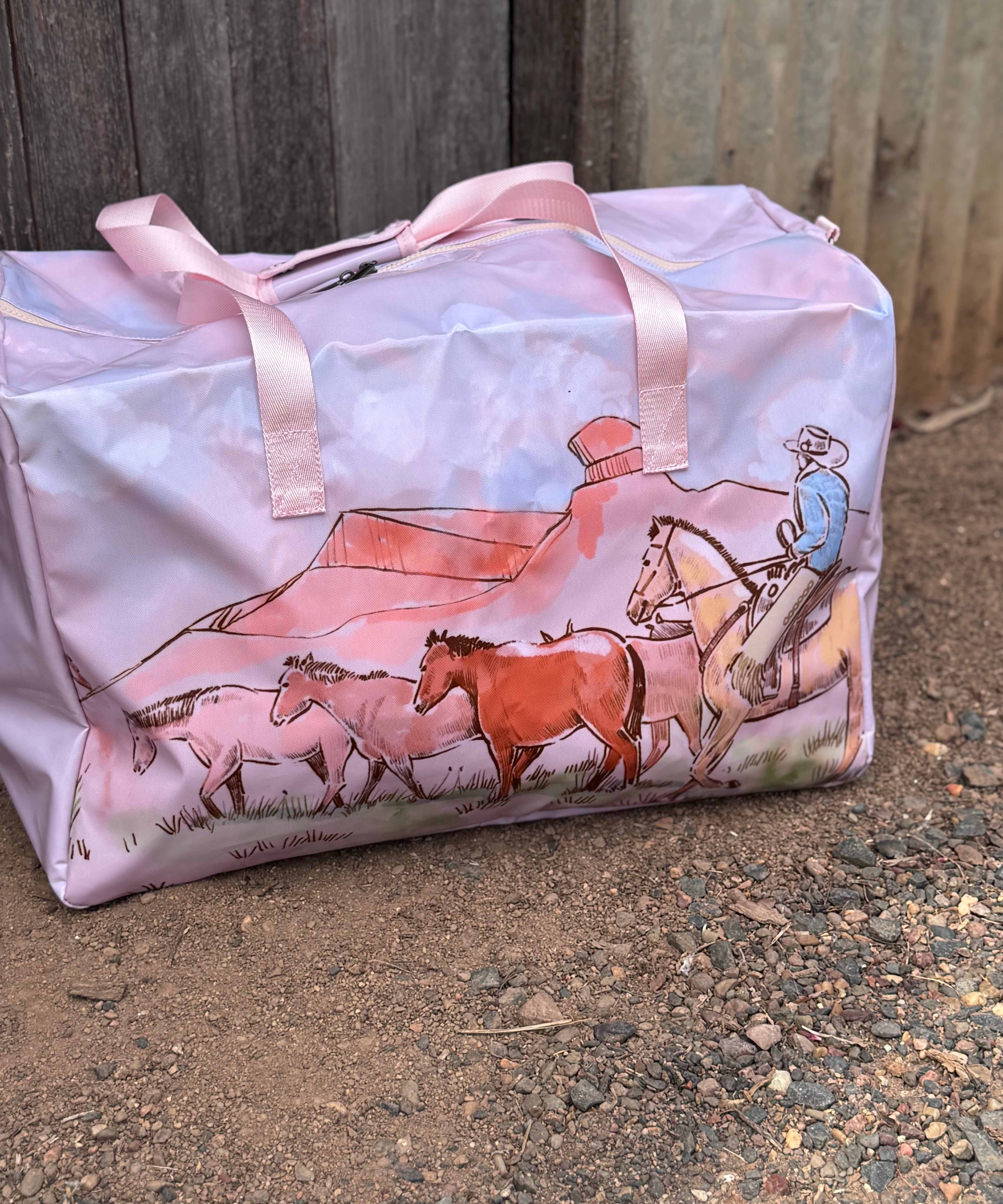 Pastel pink droving duffle bag open showing spacious interior and quality zip closure