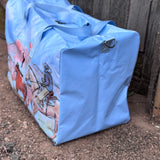 Pastel blue droving duffle bag side view showing roomy compartment and soft blue colourway