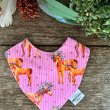 Waterproof pink horses bib showing adorable horse print design on wipeable waterproof fabric