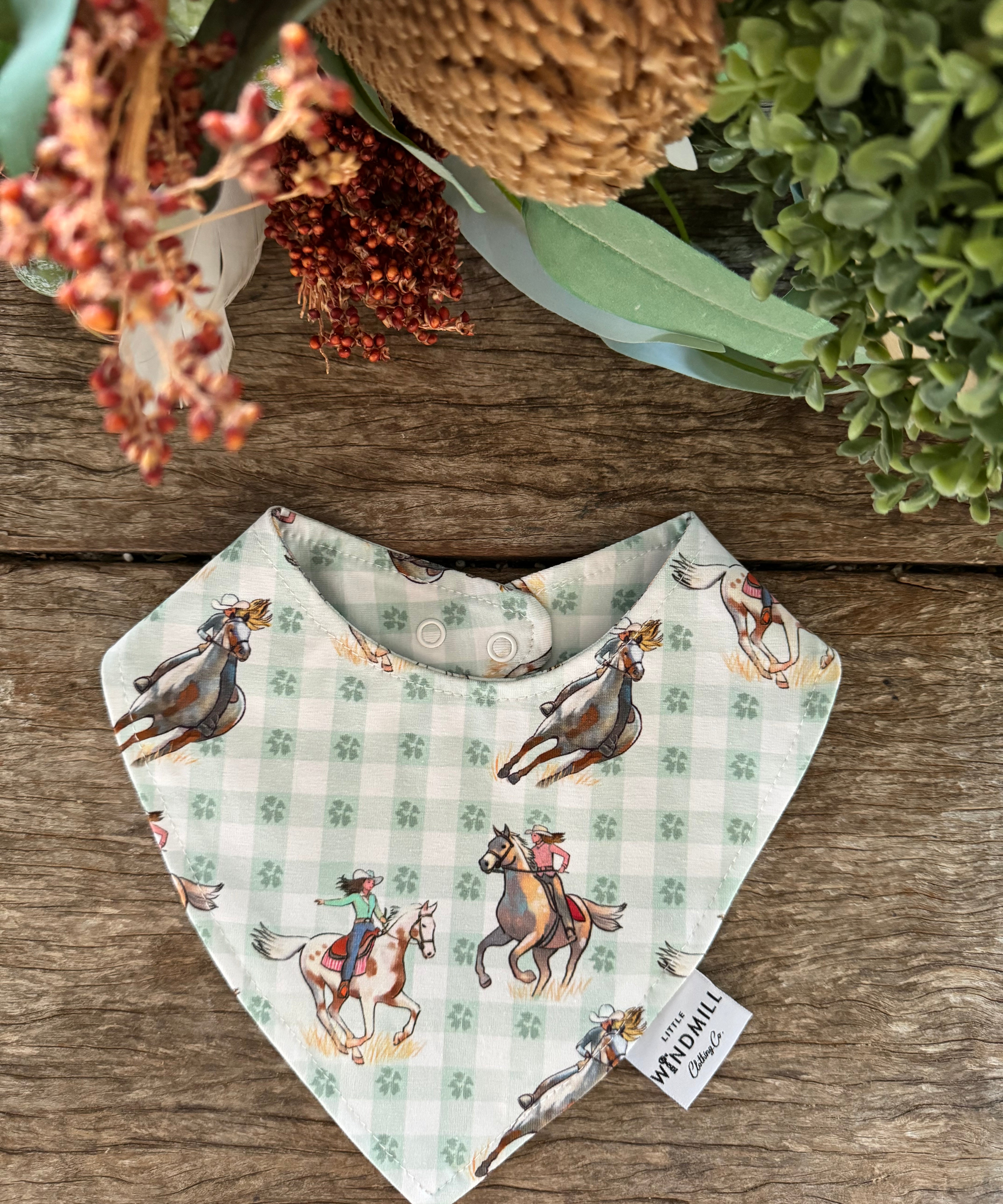 Waterproof teal cowgirl bib showing fun cowgirl print on wipeable teal waterproof fabric