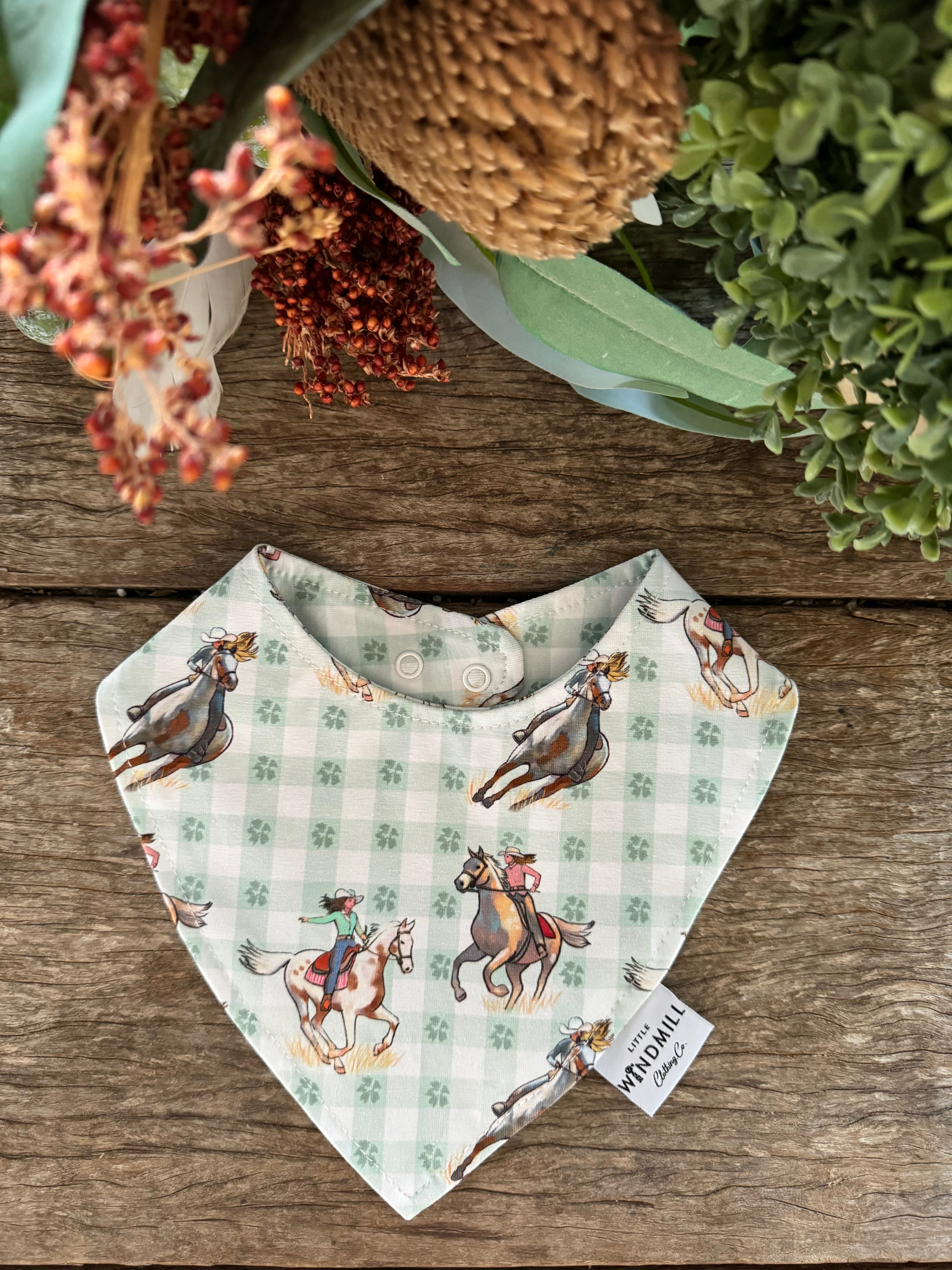 Waterproof teal cowgirl bib showing fun cowgirl print on wipeable teal waterproof fabric