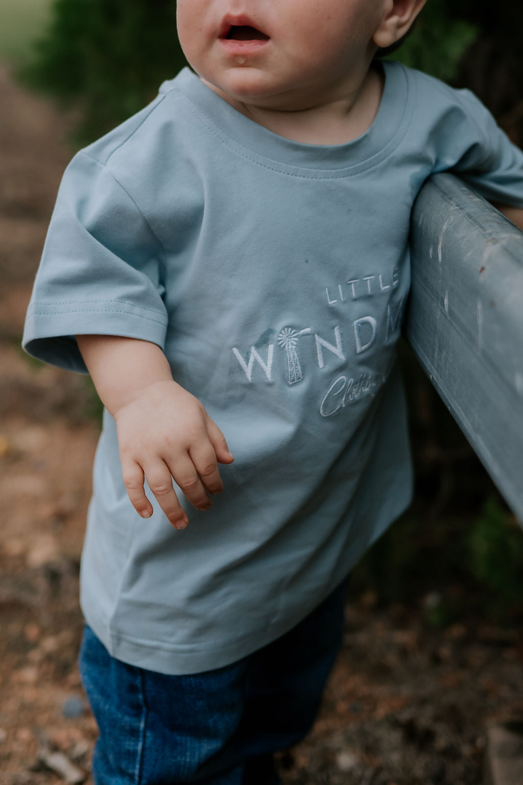 LWCC embroidered kids tee powder blue embroidery close-up showing LWCC logo stitch on powder blue