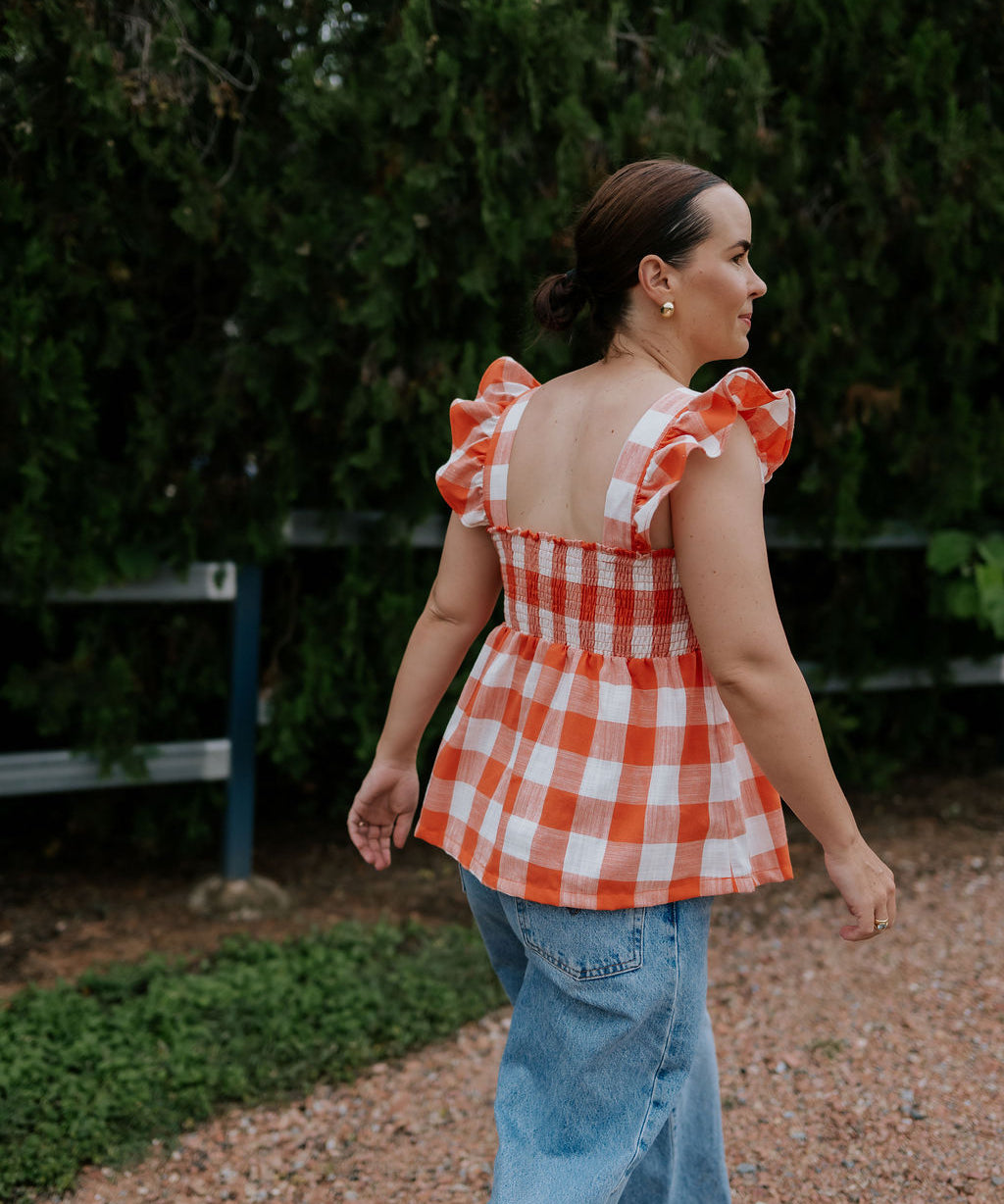 Orange check linen women's blouse back view showing relaxed women's fit in warm orange check linen