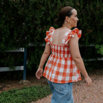 Orange check linen women's blouse back view showing relaxed women's fit in warm orange check linen