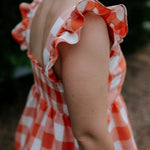 Orange check linen women's blouse flatlay showing full linen blouse design in warm orange check
