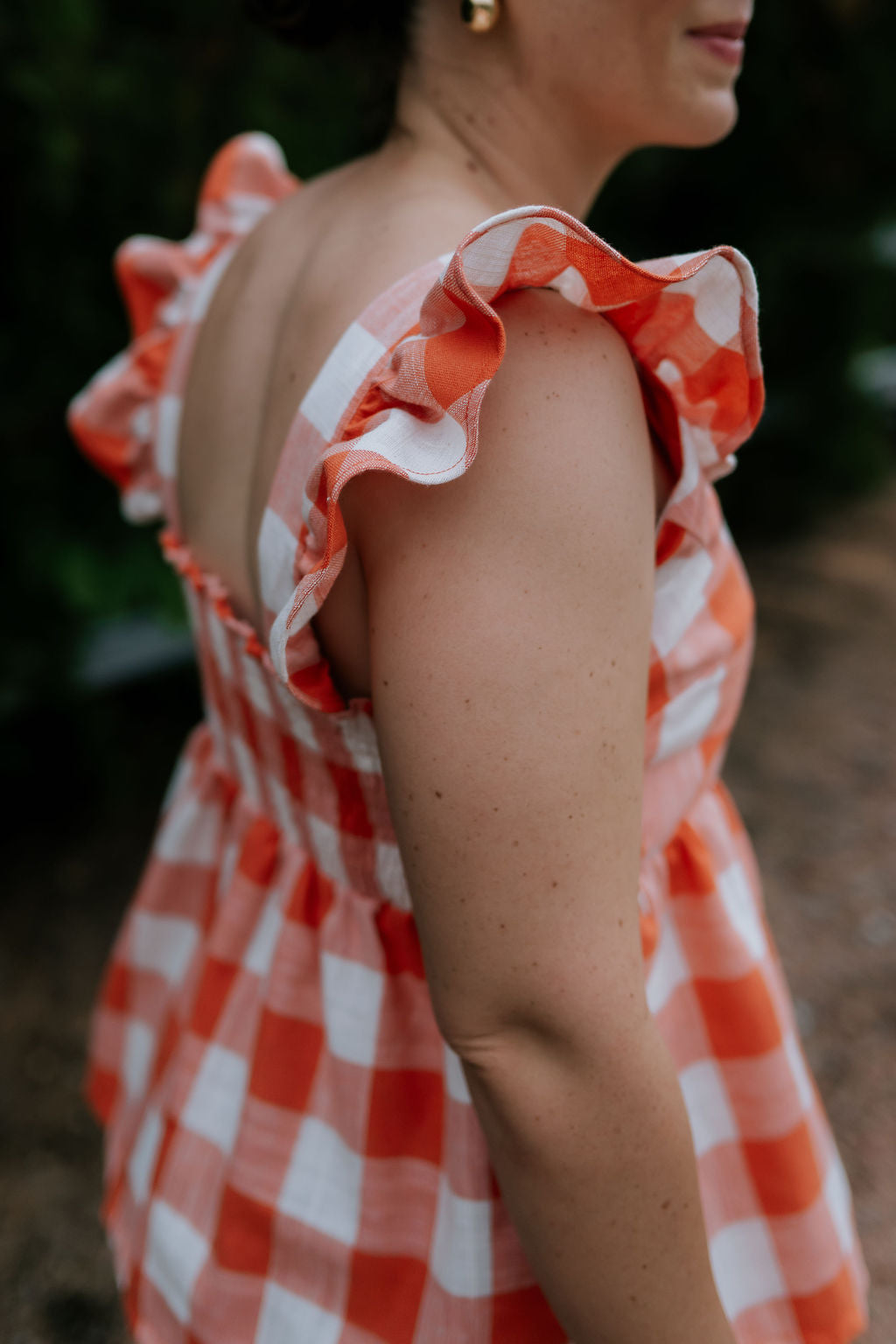 Orange check linen women's blouse flatlay showing full linen blouse design in warm orange check