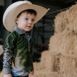 Child wearing a cowboy hat in a barn setting