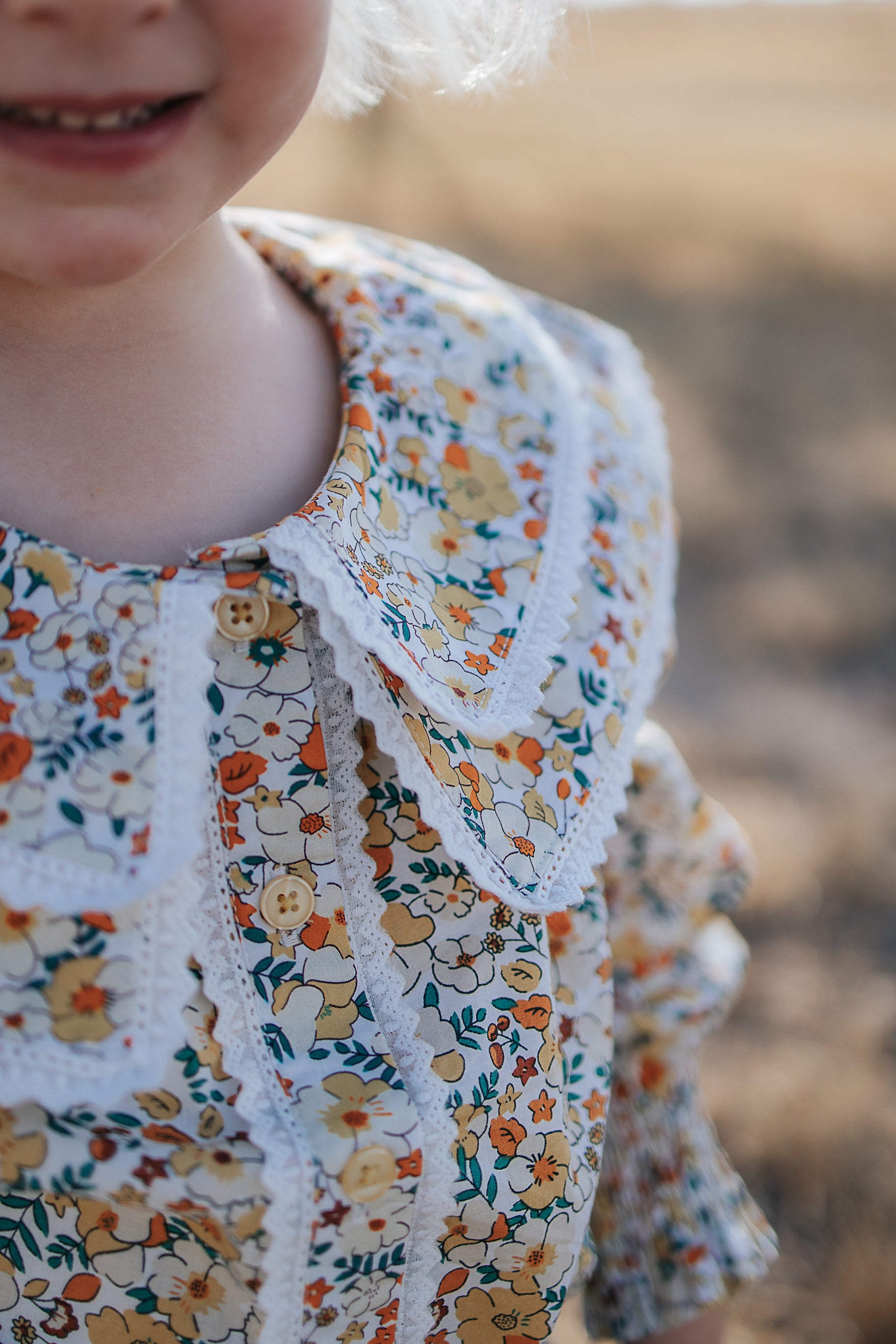 Elsie girls butter yellow floral long sleeve blouse fabric close-up showing quality yellow floral cotton