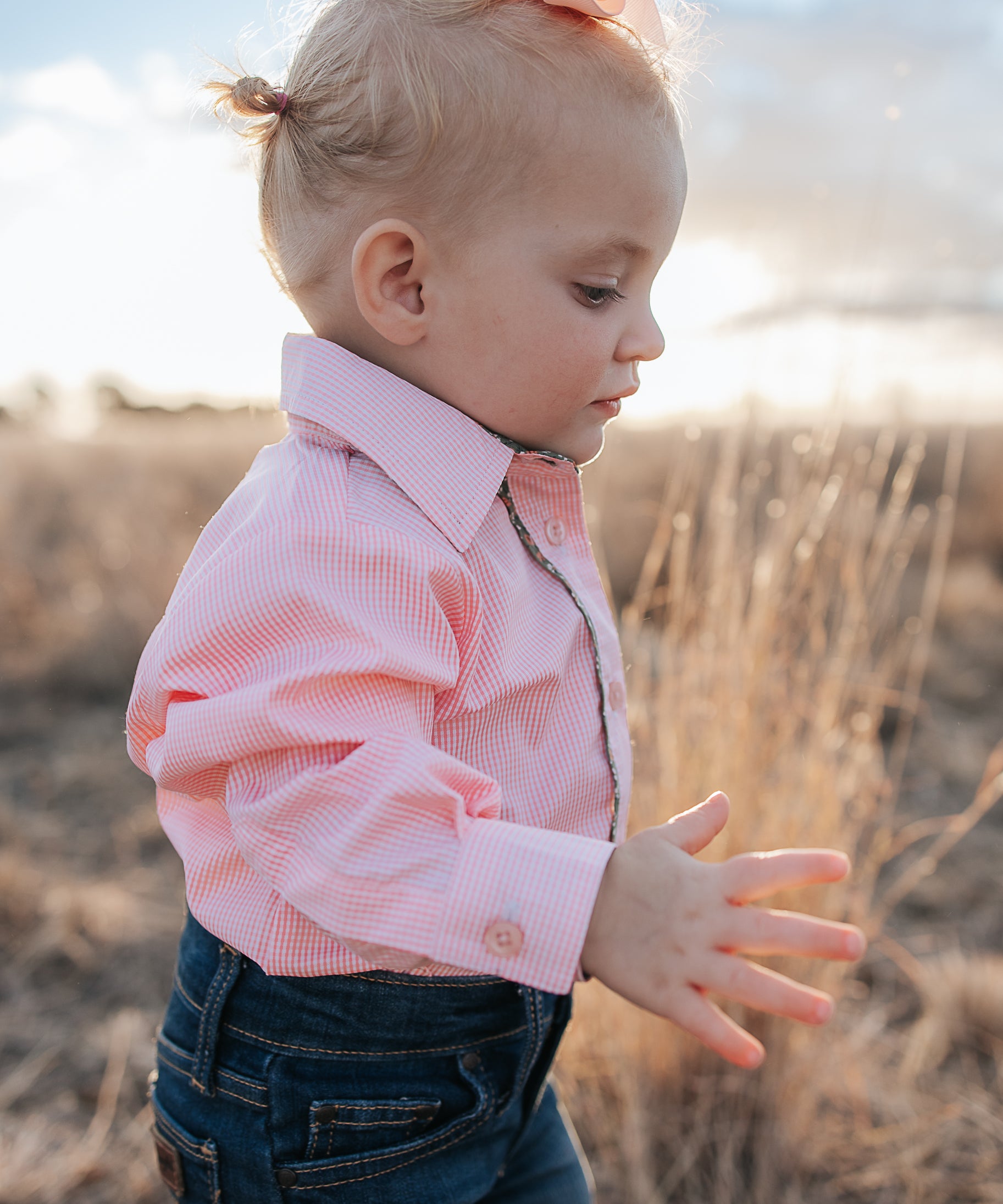 Chloe coral gingham long sleeve romper back view showing snap closure and coral gingham fabric