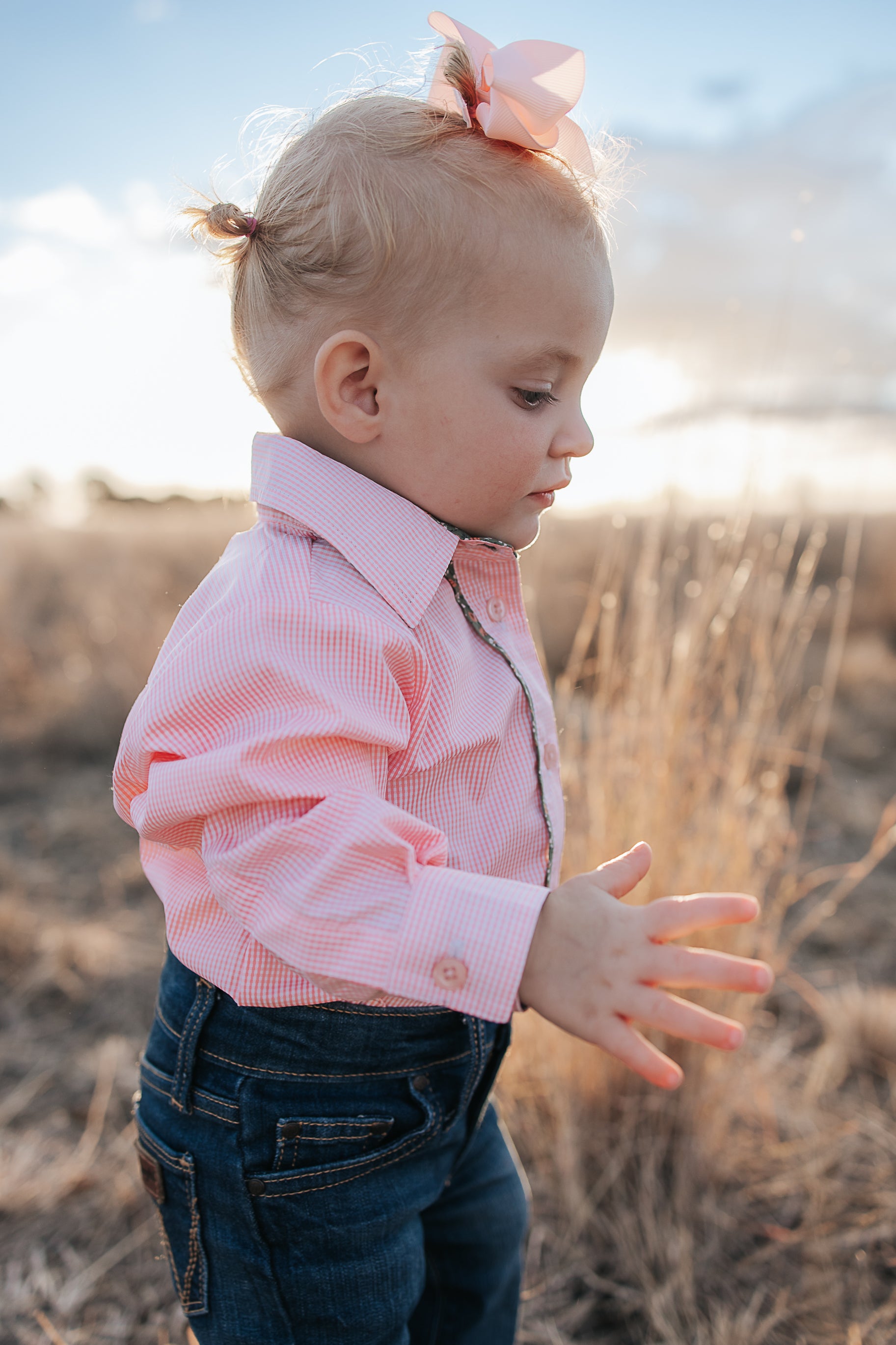 Chloe coral gingham long sleeve romper back view showing snap closure and coral gingham fabric