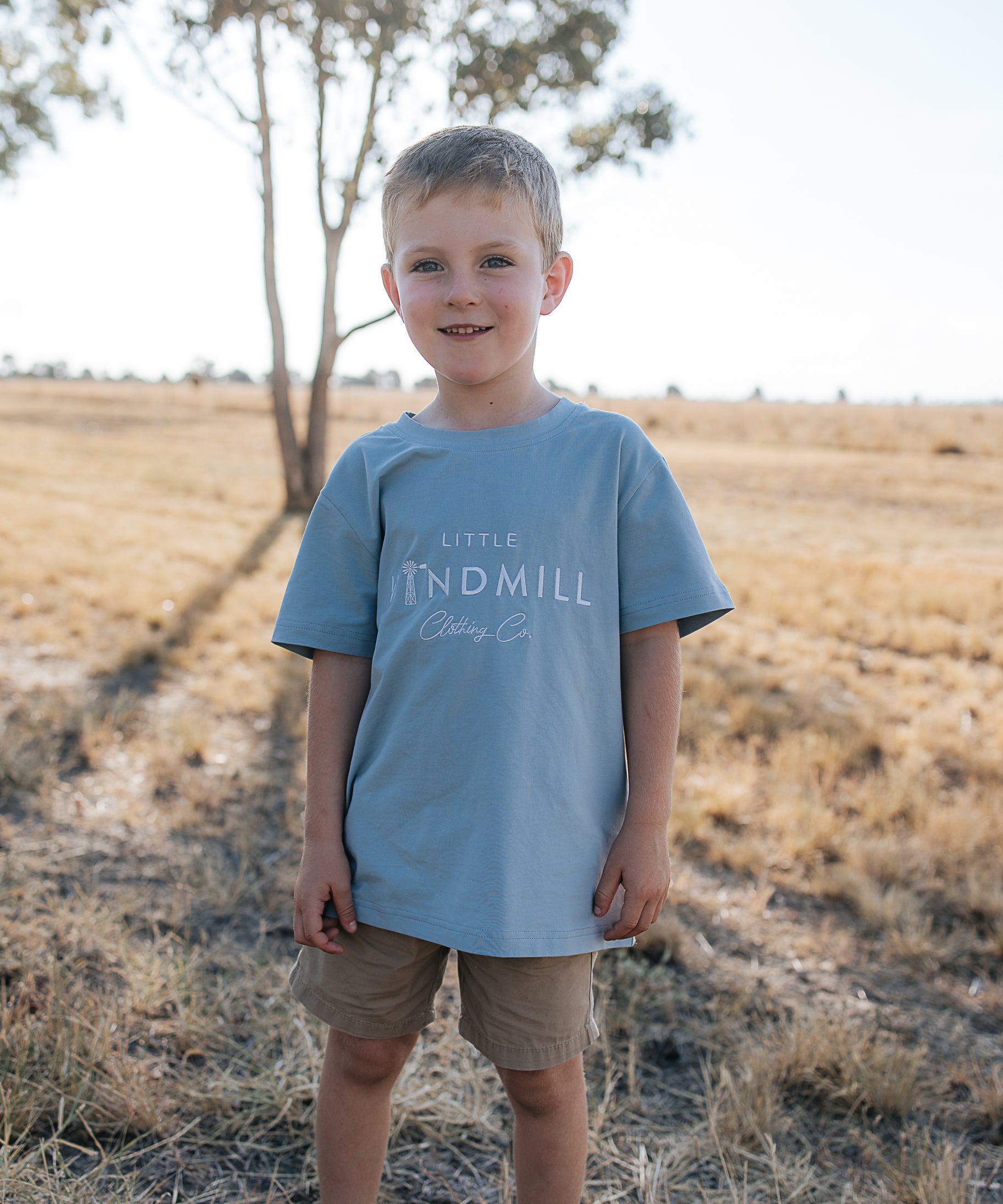 LWCC embroidered kids tee powder blue front view showing signature LWCC logo on soft powder blue