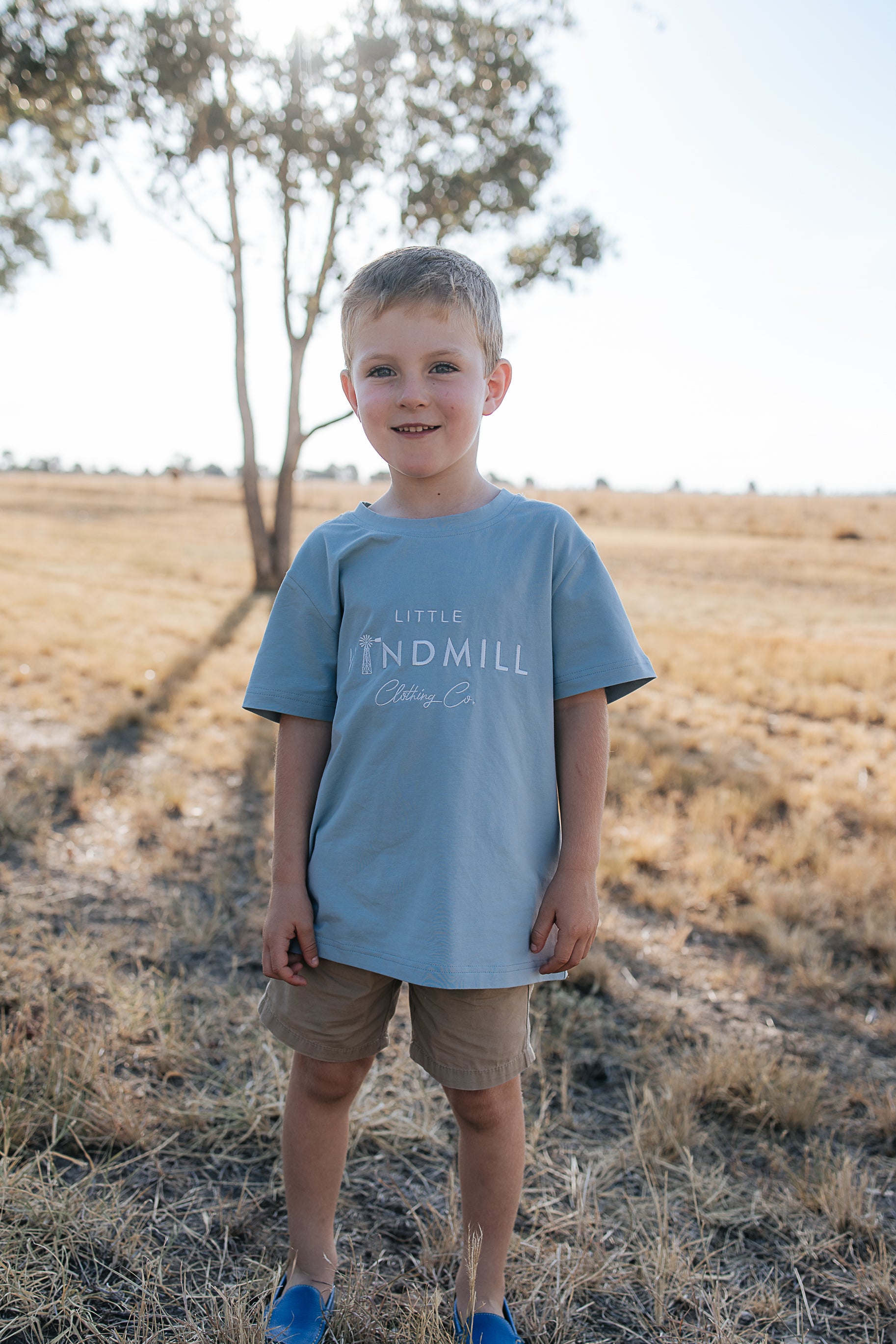 LWCC embroidered kids tee powder blue front view showing signature LWCC logo on soft powder blue